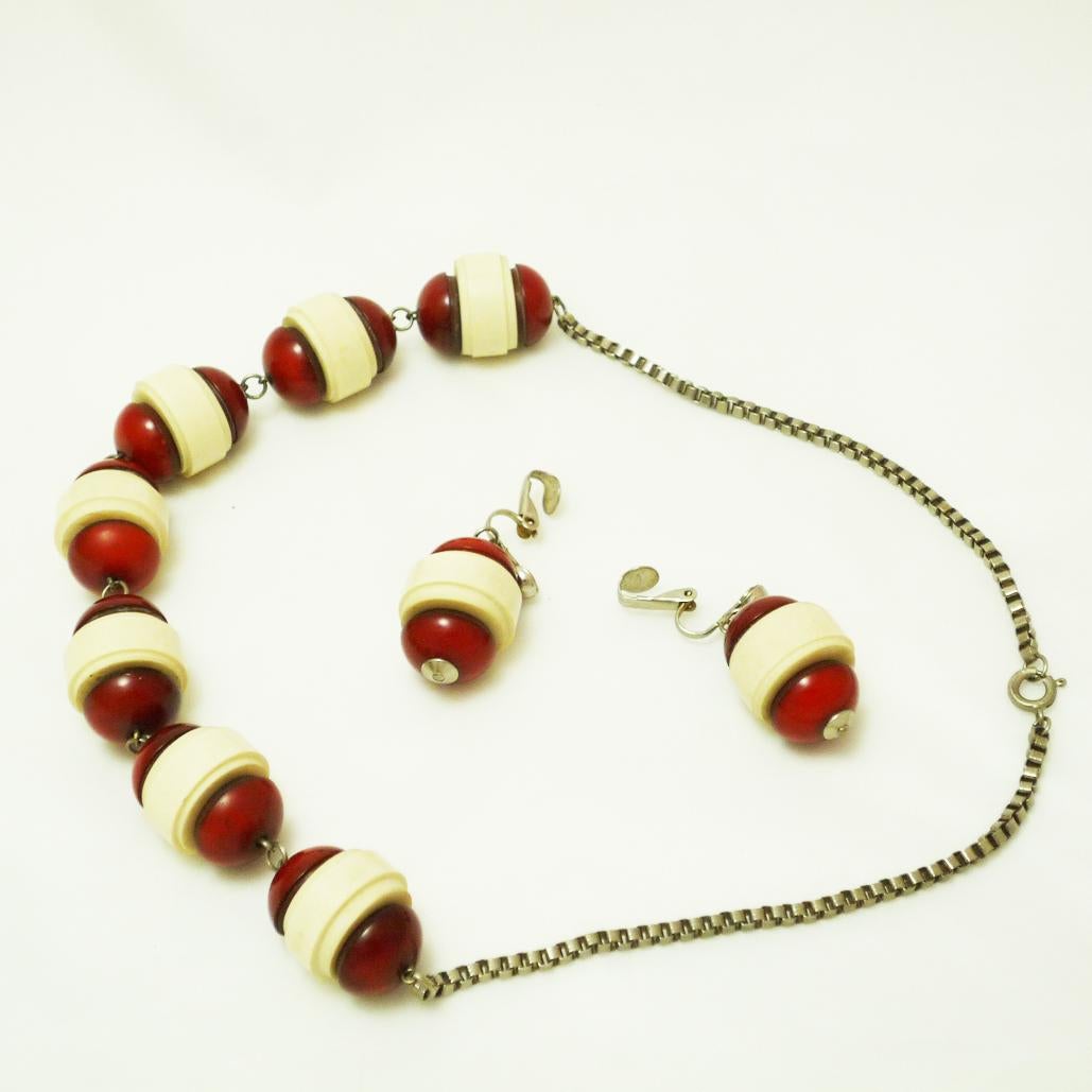 Bakelite necklace with earrings
Art Deco necklace with barrel shaped bakelite elements with matching earclips,

beautiful example for the classical jewellery of the Art Deco.

Chain length: 47 cm

D of the individual elements: 2 cm, H: 2.5