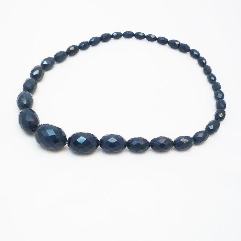 Collana in bachelite con taglio a faccette

collana di olive in bachelite blu, taglio a sfaccettatura, con tappo a vite

lunghezza della catena: 41 cm

F: 1920-30