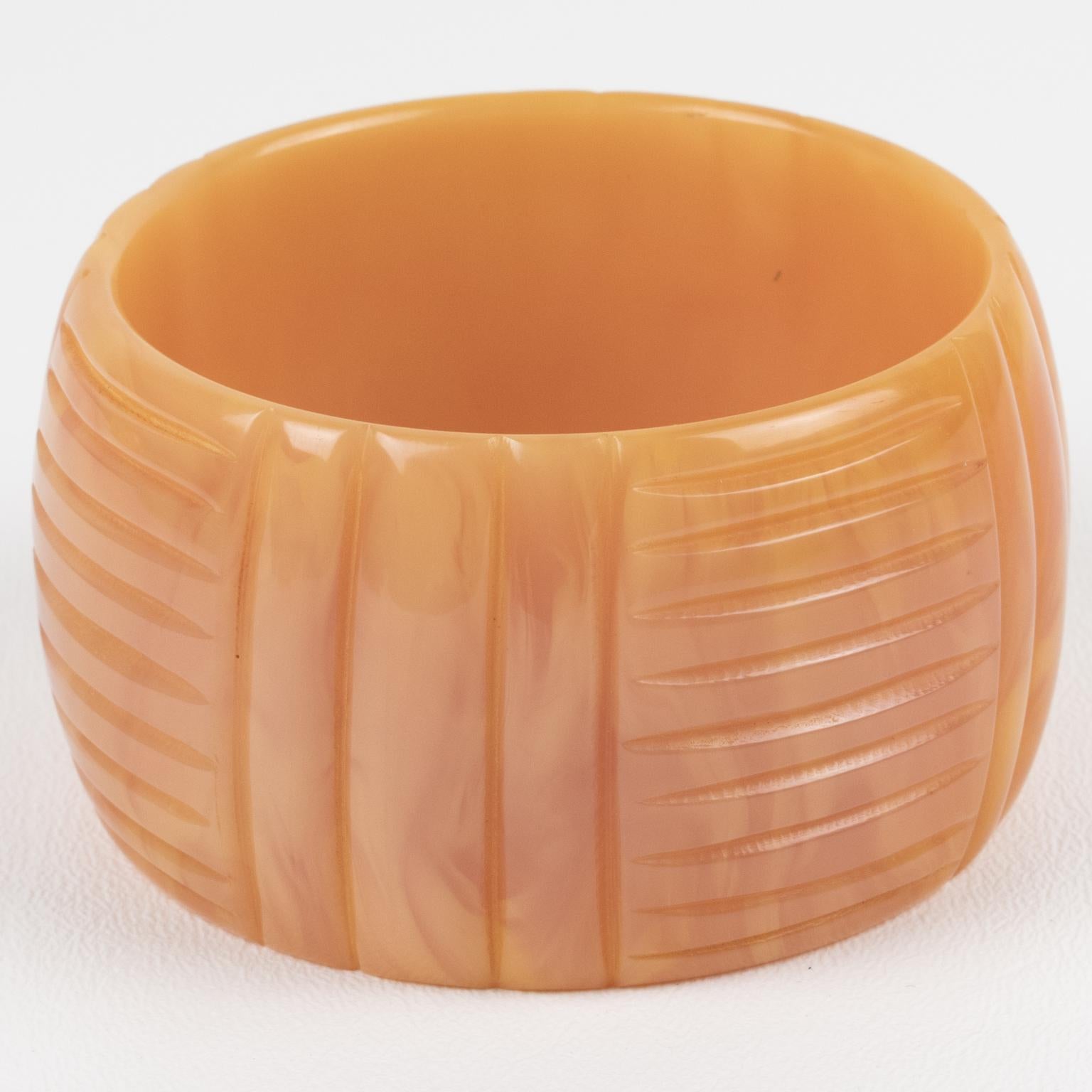 This is a gorgeous pink carnation marble Bakelite carved bracelet bangle. It features a chunky oversized domed shape with a geometric carving design. The color is an intense light powder pink with milky and pale yellow cloudy swirling.