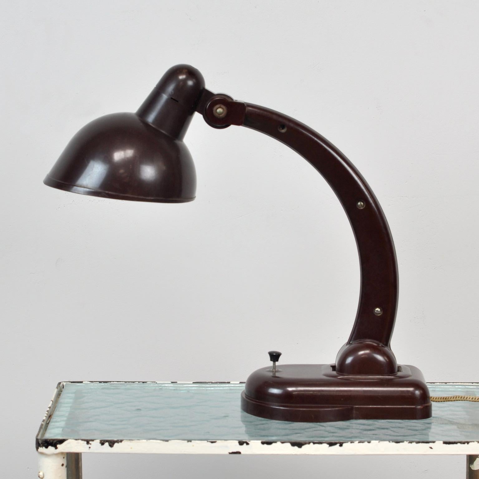 Desk lamp made from bakelite. Designed by Christian Dell in 1930. The lamp was manufactured by Heinrich Römmler AG, Preßstoffwerke, Spremberg circa 1932. It features an adjustable arm and cap. The table lamp was used in all administrative