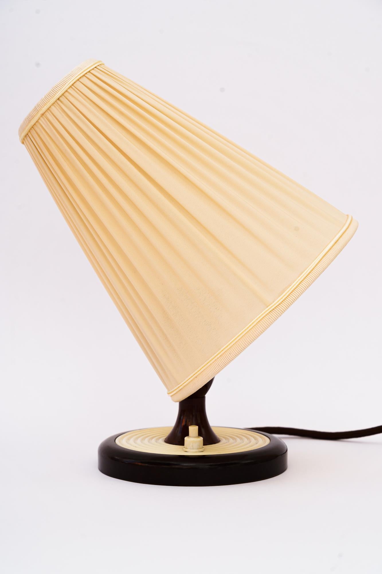 Bakelite table lamp Vienna with Fabric Shade Around 1960s.
Original condition.
the fabric shade is replaced ( new ).