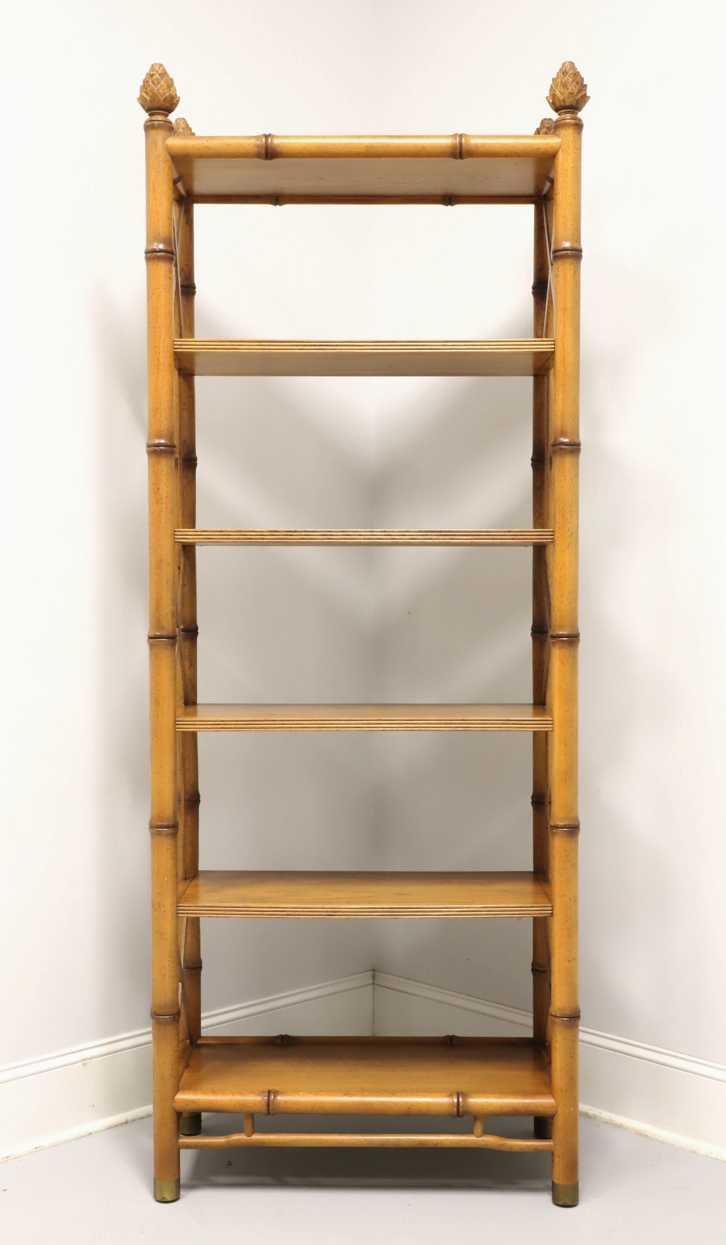 A Hollywood Regency style etagere / display shelving unit by Baker Furniture. Light color stained walnut, ornamental faux bamboo, decorative open frame, alternating per shelf straight 