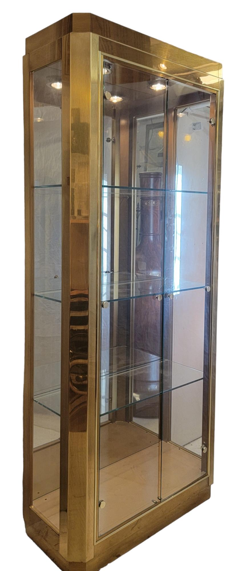 Three shelf brass and glass baker and company display case. beautiful edges on all corners. The brass  does show some signs of use with minor scratching to the surface. The glass is all intact an in great condition. The doors open and close with