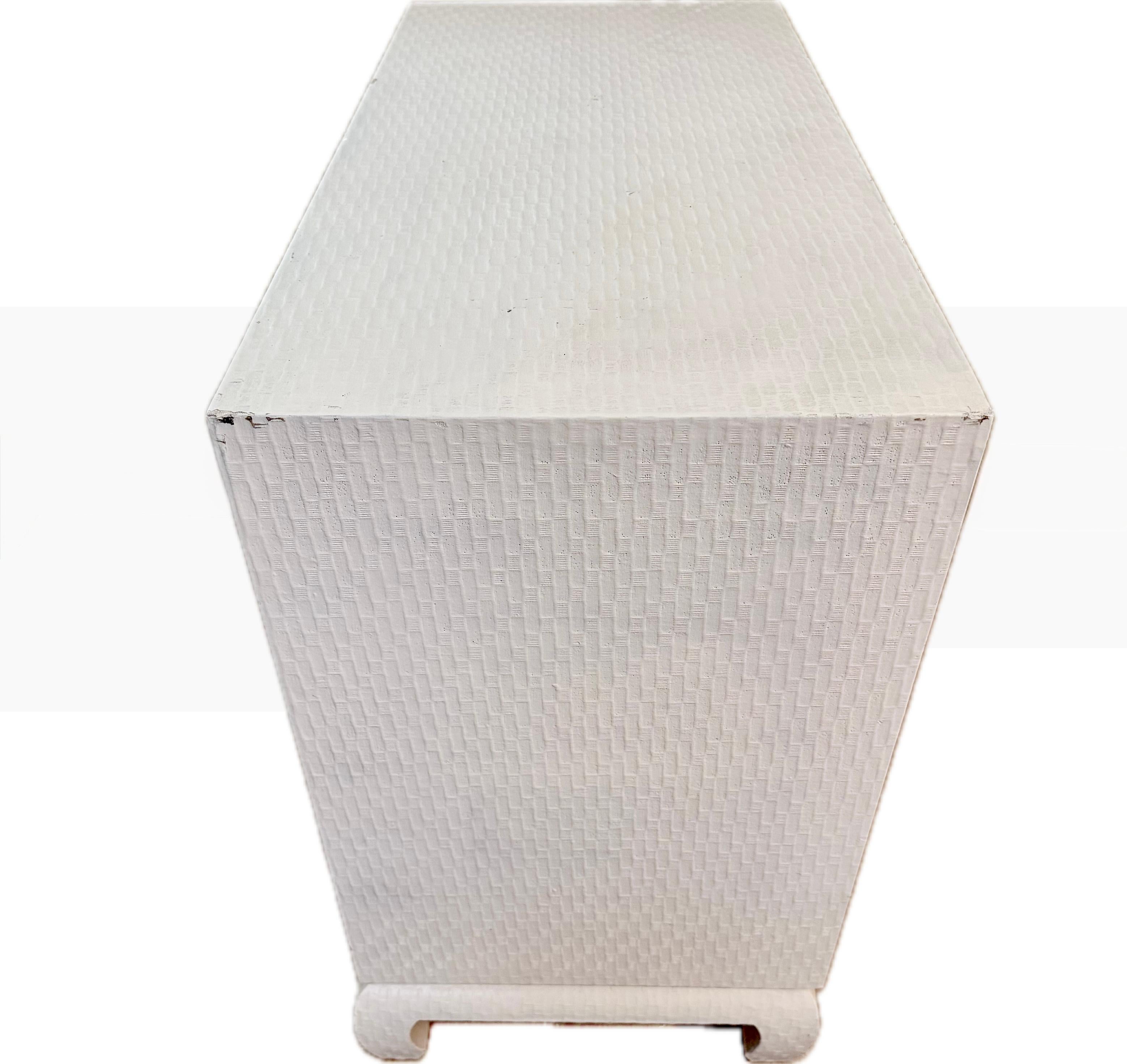 Chic, Rare find-- A fabulous Hollywood Regency style grass cloth raffia cream lacquer mid century Cabinet by Baker Furniture. Feature a smooth, glossy lacquered grass cloth and a sleek, rectangular silhouette-epitomizing the sophisticated yet laid