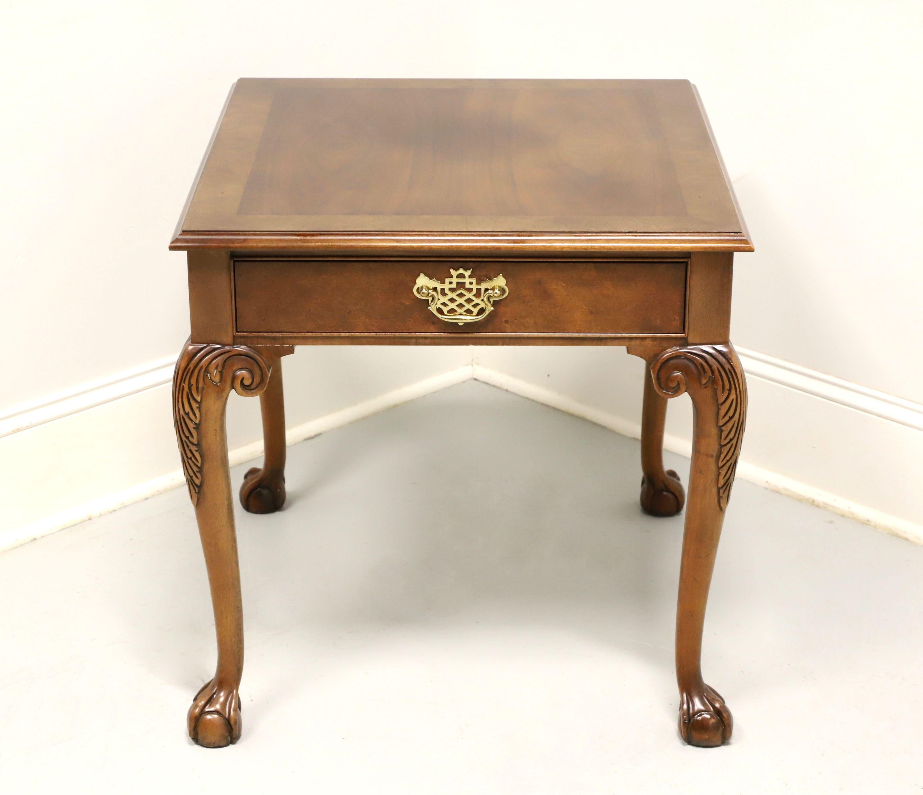 A Chippendale style rectangular side table by Baker Furniture. Solid walnut with burl walnut banded top, brass hardware, carved acanthus leaves to knees, cabriole legs and ball in claw feet. Features one drawer of dovetail construction. Made in