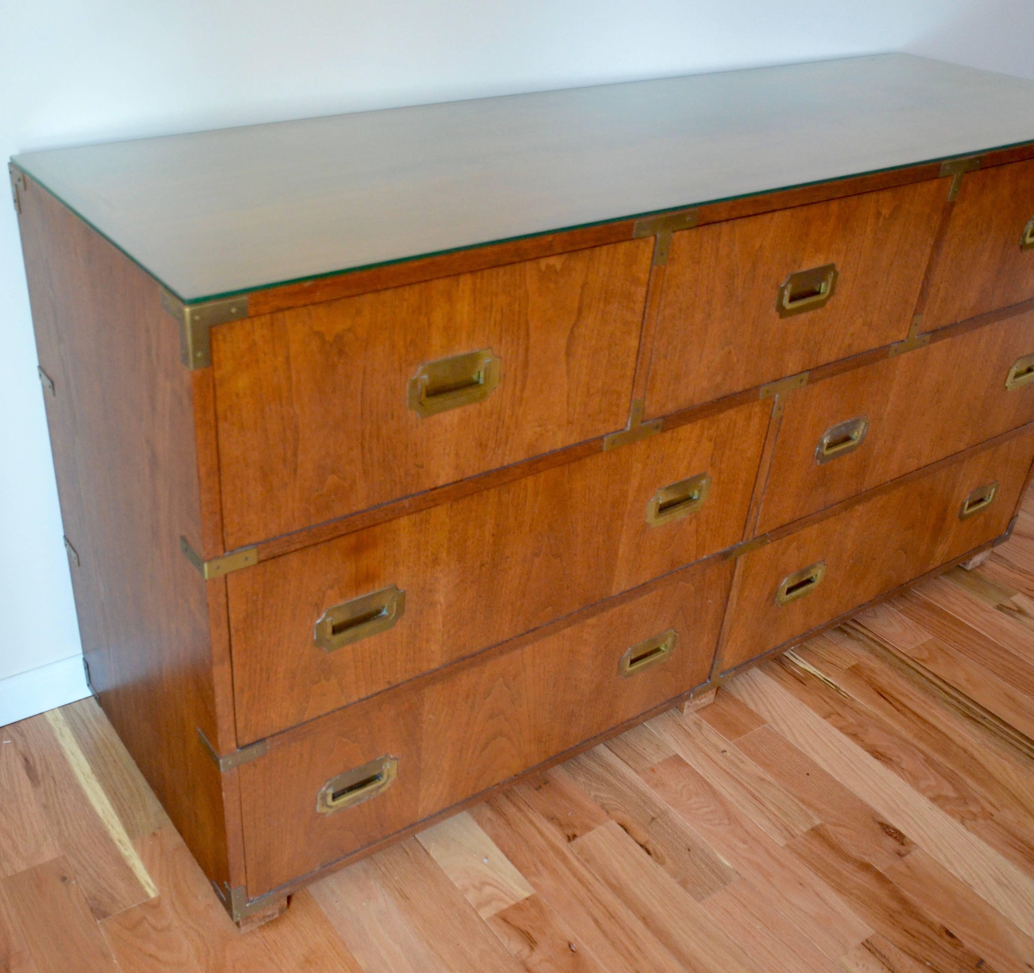 Campaign style mahogany dresser by Baker Furniture. In outstanding condition, this dresser features recessed brass Campaign handles and corner detailing on both the front and sides. The dresser has three drawers on the top row and four more larger