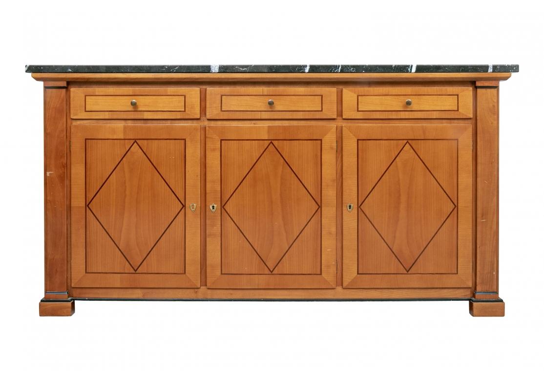 Classic lines with three apron drawers over three doors, all with dark painted string inlay type details, the doors in a diamond motif and two with brass shield form escutcheons and two keys. The two doors open to compartments (lacking shelves). The