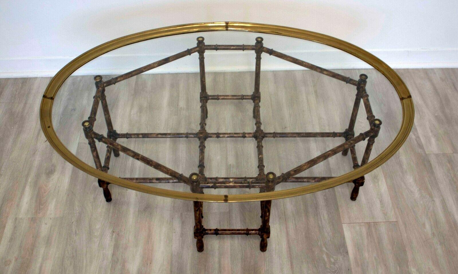 This lovely Baker, Chippendale style coffee table is detailed with a faux bamboo base made of brass with a glass and matching brass oval top. This style would work well in any Hollywood Regency style home. In good vintage condition, it measures 44 W