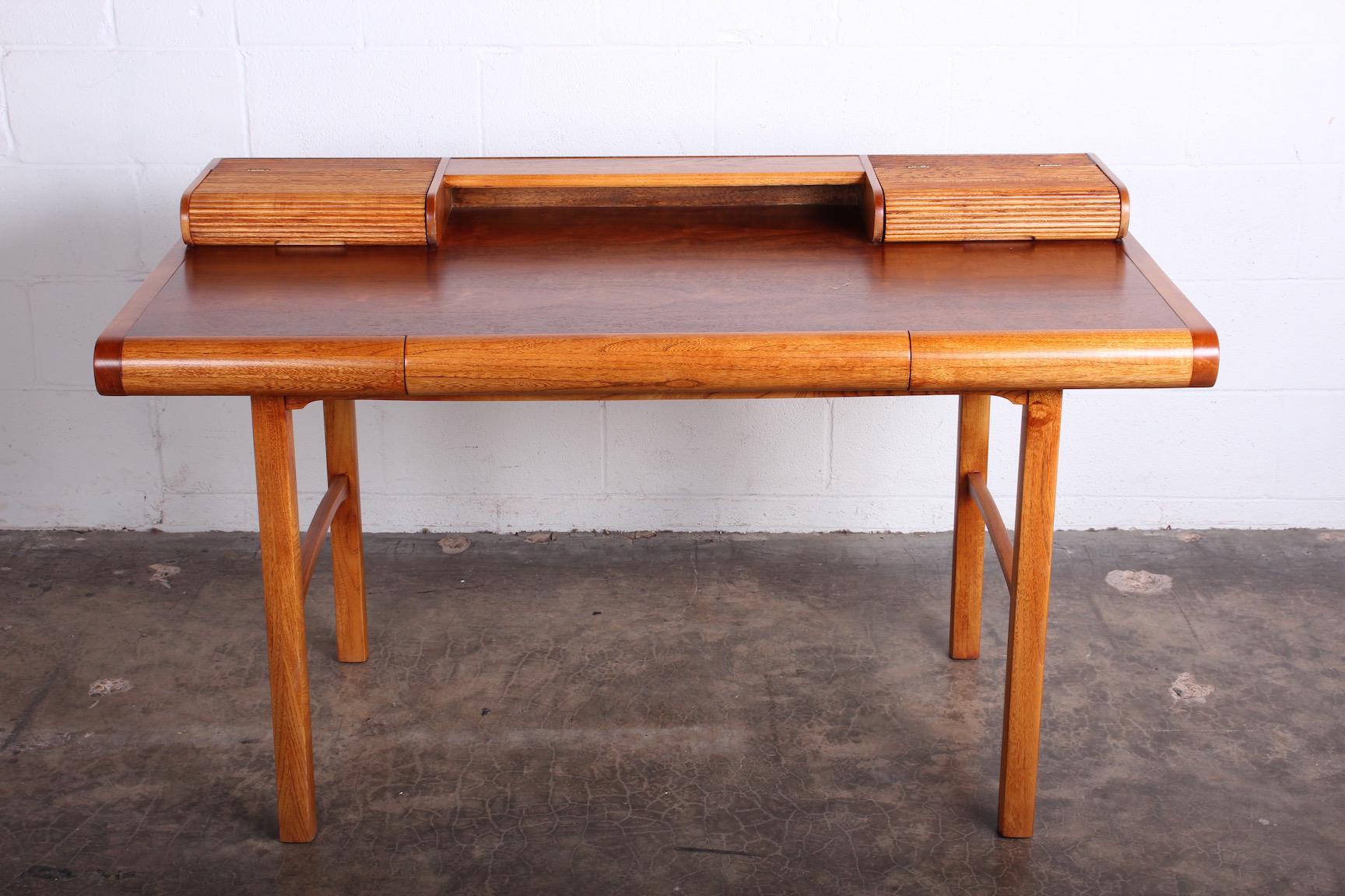A nicely detailed petite desk by Baker. Oak and walnut with hinged compartments at top. 
Desktop height 28.75