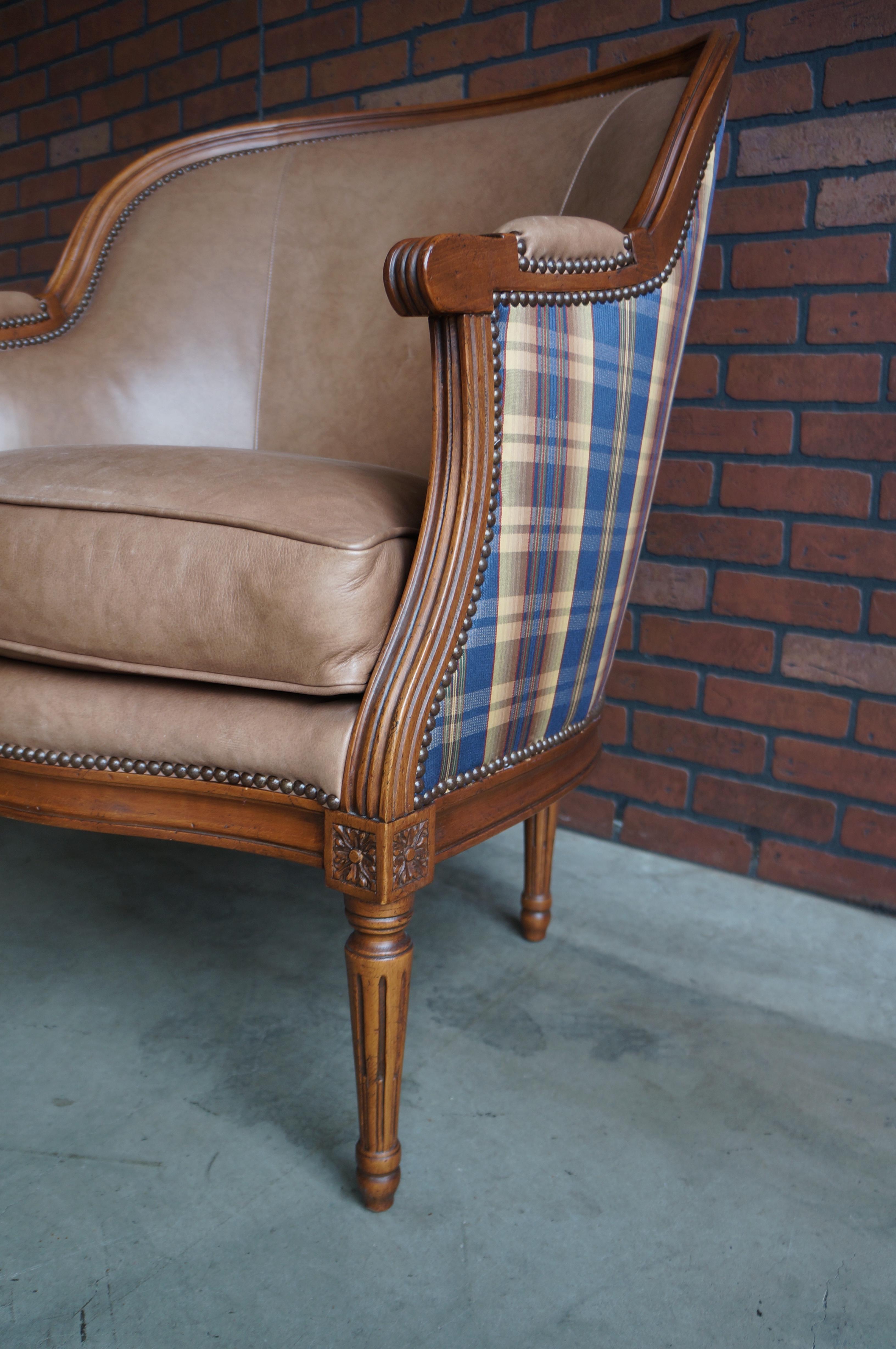 Exceptional quality and styling combine to give this Baker Furniture chair unending durability and timeless appeal.  Featuring a carved wood frame with dual leather and fabric upholstery with nailhead trim.