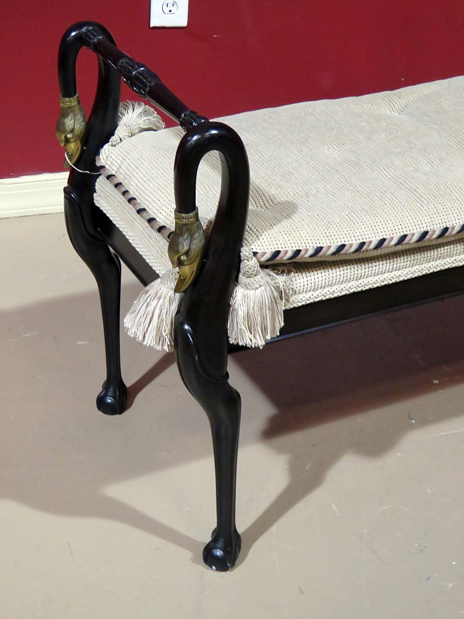 Baker ebonized Empire style window bench with brass accents and ball & claw feet.