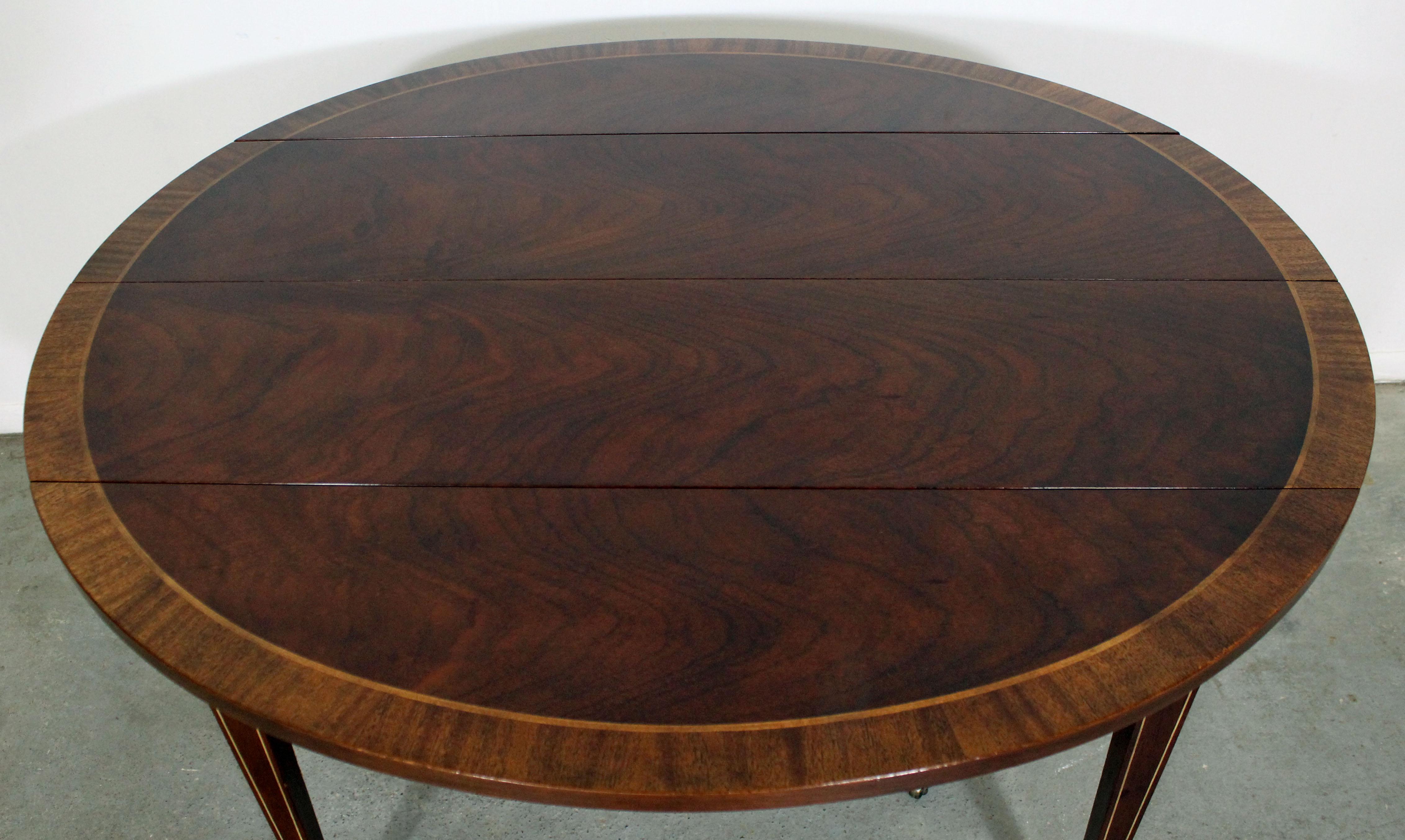 Offered is a Baker Federal style banded mahogany expansion dining table. The table has 3 boards. It's a great space saving table as it can be used round as well. The table is signed Baker. The table is in great condition, showing some wear from age