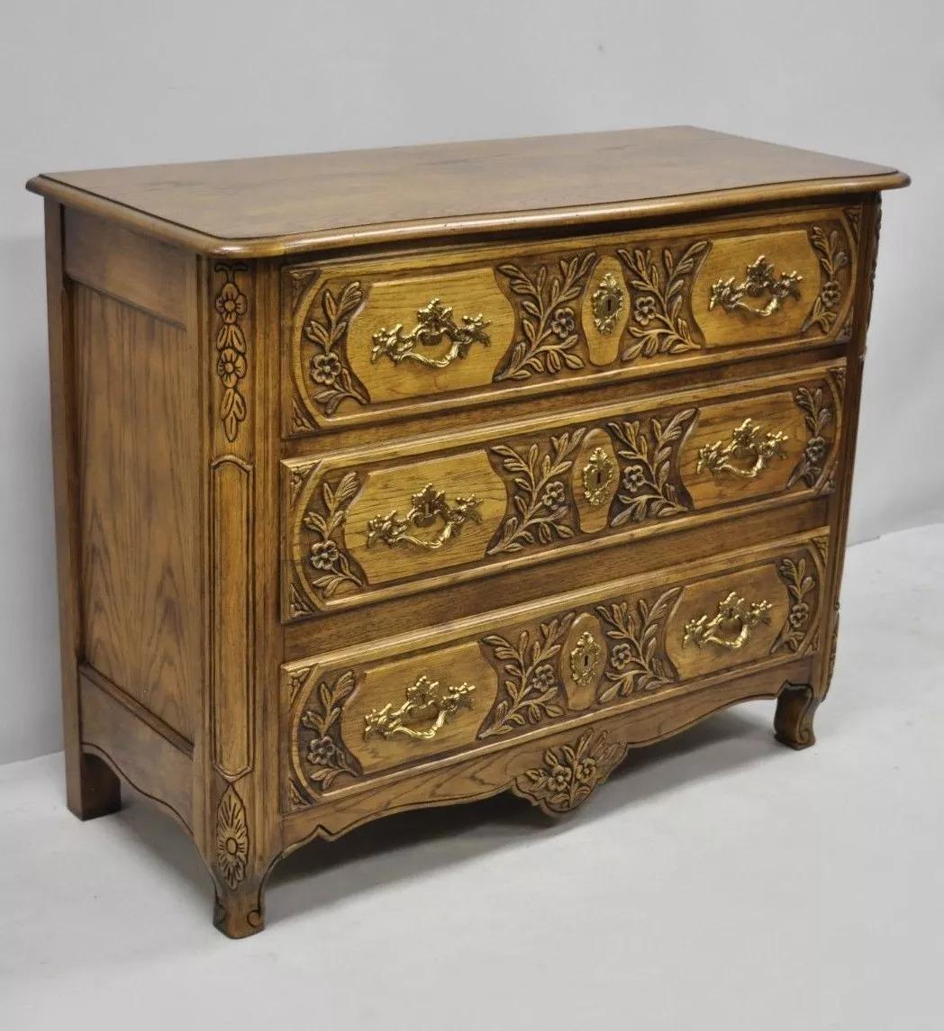 Cassettiera Baker in stile provinciale francese intagliata in Oak Wood. L'articolo presenta una struttura in legno massiccio, bellissime venature del legno, dettagli ben intagliati, etichetta originale, 3 cassetti a coda di rondine, ferramenta in