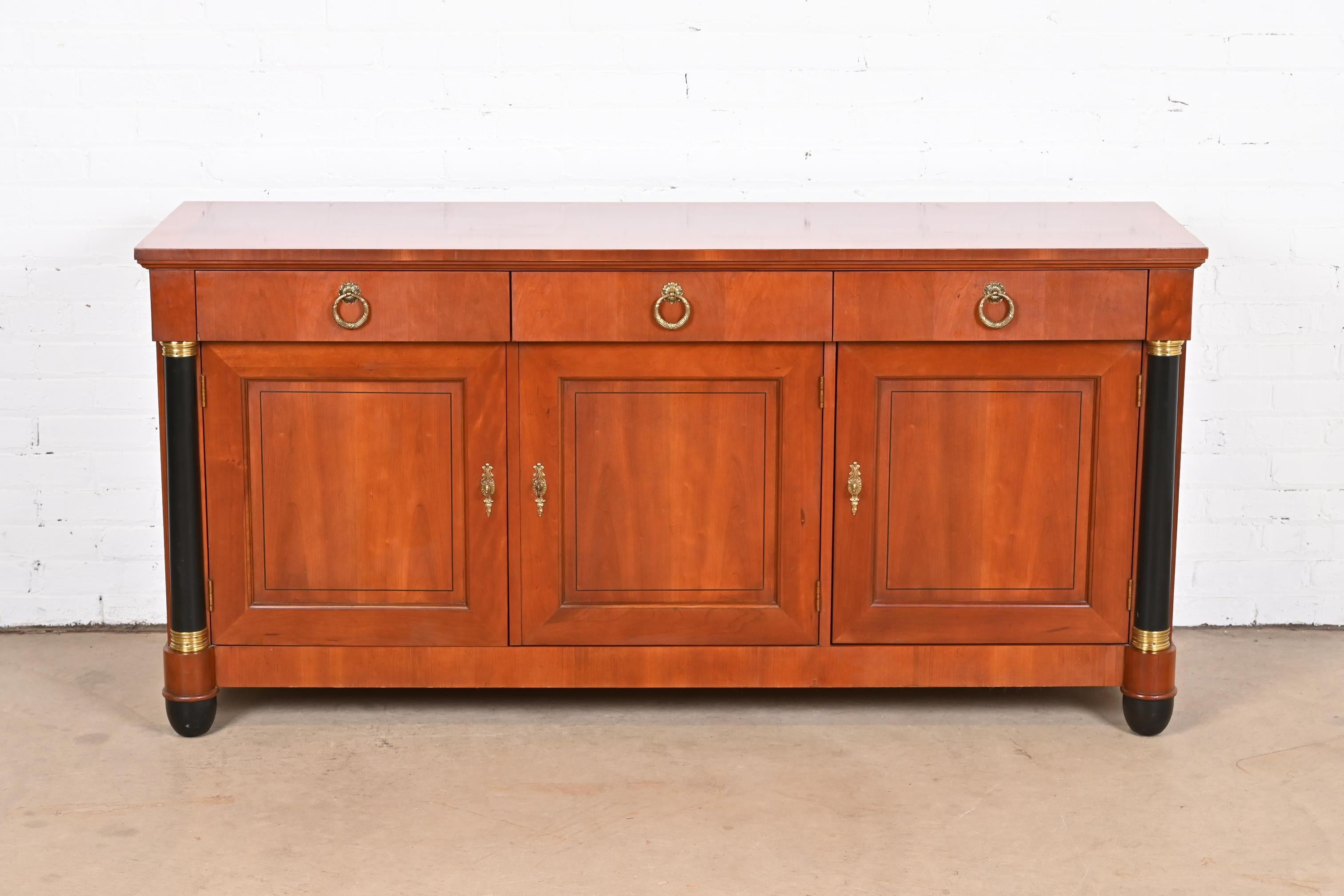 A gorgeous French Empire or Neoclassical style sideboard, credenza, or bar cabinet

By Baker Furniture

USA, circa 1980s

Carved cherry wood, with ebonized columns and feet, and original brass hardware.

Measures: 66
