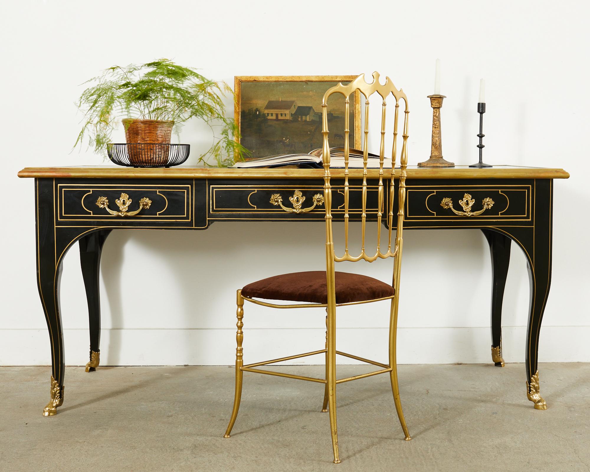 Opulenter französischer Schreibtisch im Louis XV-Stil, hergestellt von Baker Furniture. Der Schreibtisch verfügt über eine patinierte, bronzefarbene, lederbezogene Schreibfläche. Die Front des Gehäuses besteht aus drei Schubladen mit polierten,