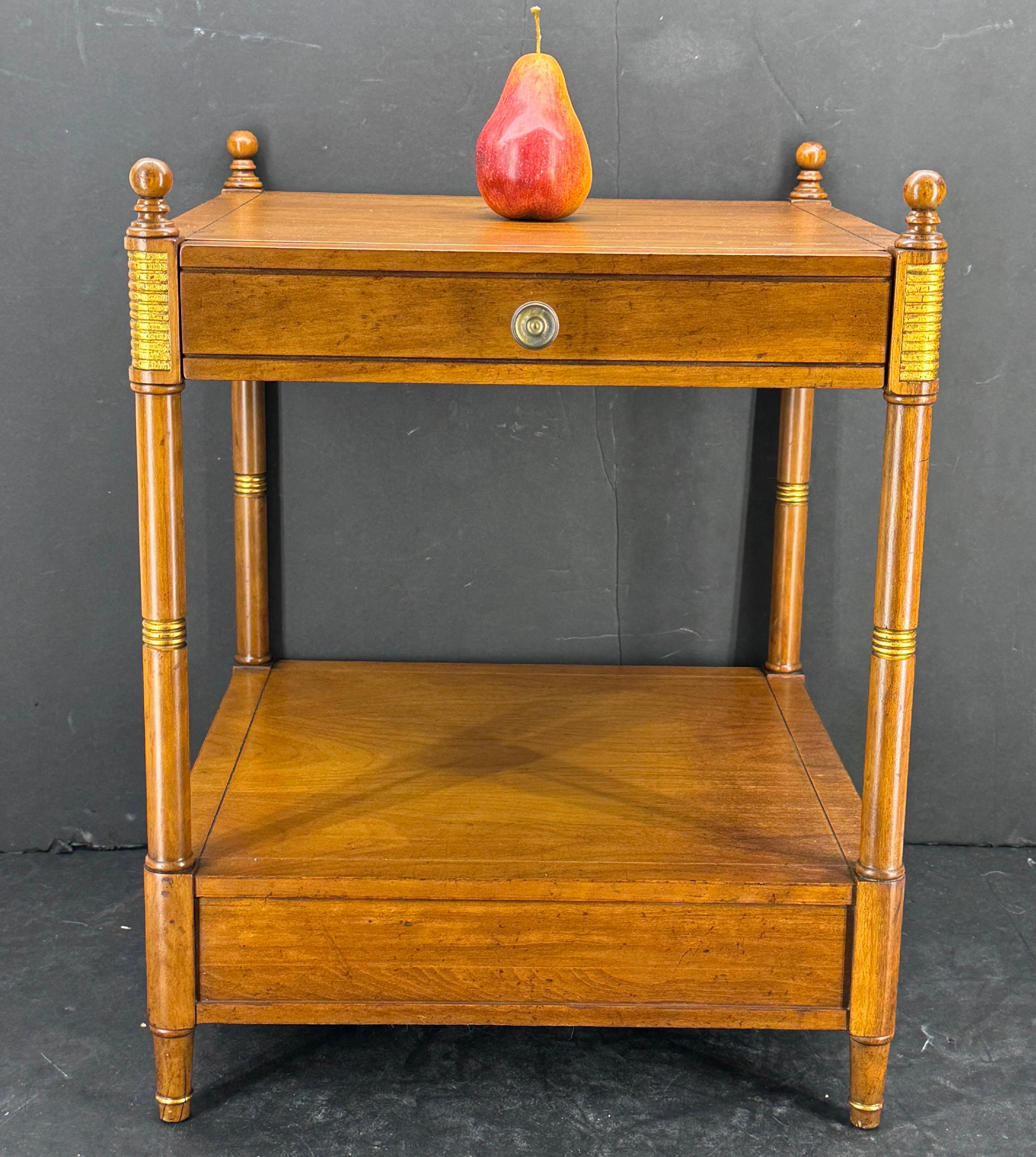 Neoclassical style side table with one drawer from Baker Furniture. The ribbed gold accents on the corners certainly add detail. We see this classic piece styled next to a chair and stacked with your favorite antique books. Marked with Baker