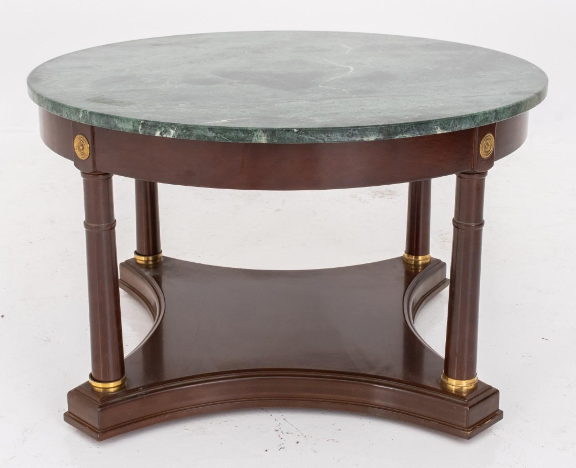 Table basse circulaire de style néoclassique à plateau en marbre vert, reposant sur quatre colonnes et une base carrée concave, probablement fabriquée par Baker Furniture.

18 pouces de hauteur et 29 pouces de diamètre