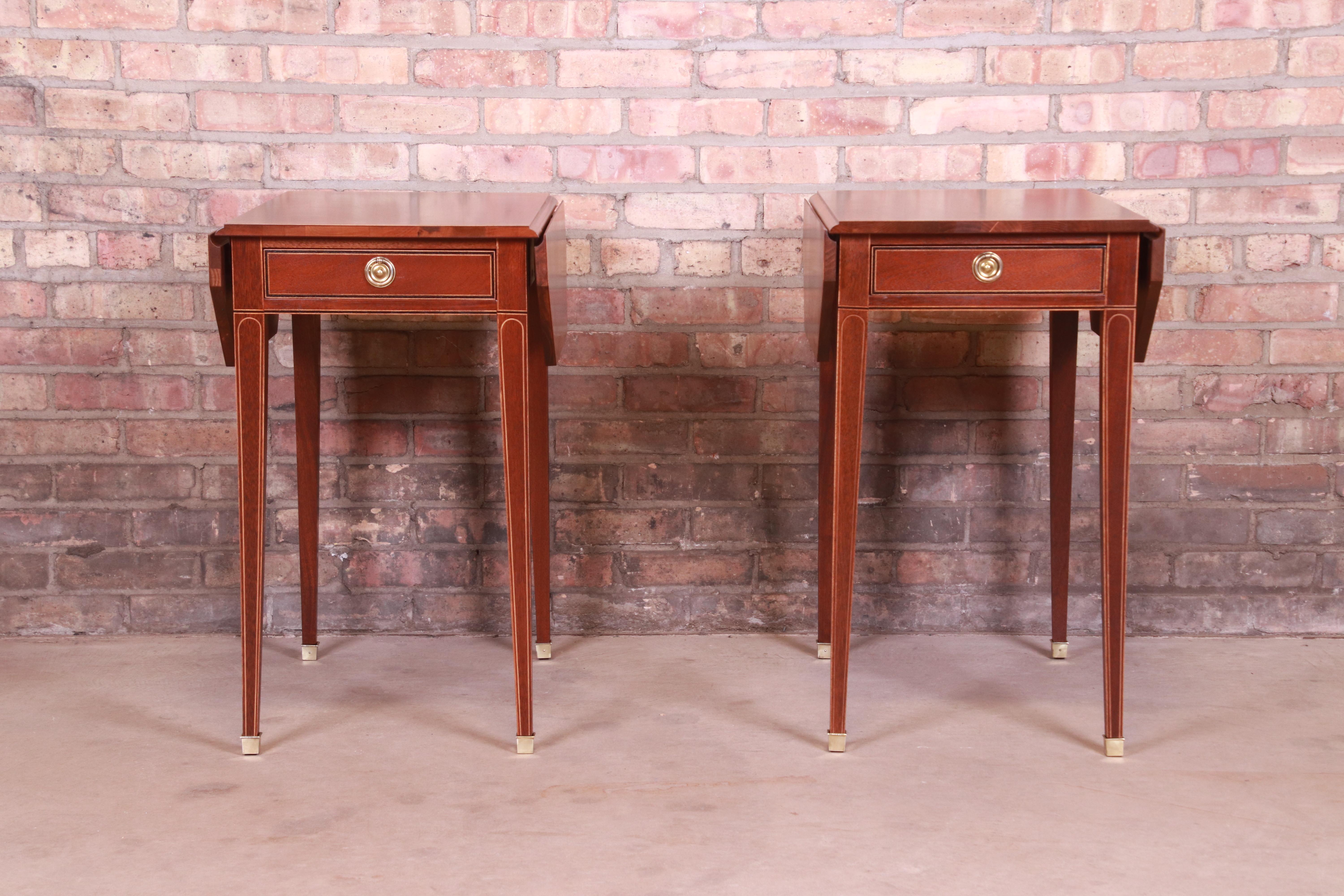 A gorgeous pair of Sheraton style Pembroke nightstands, end tables, or tea tables

By Baker Furniture

USA, Late 20th Century

Mahogany, with satinwood and ebonized string inlay, original brass hardware, and brass-capped feet.

Measures: