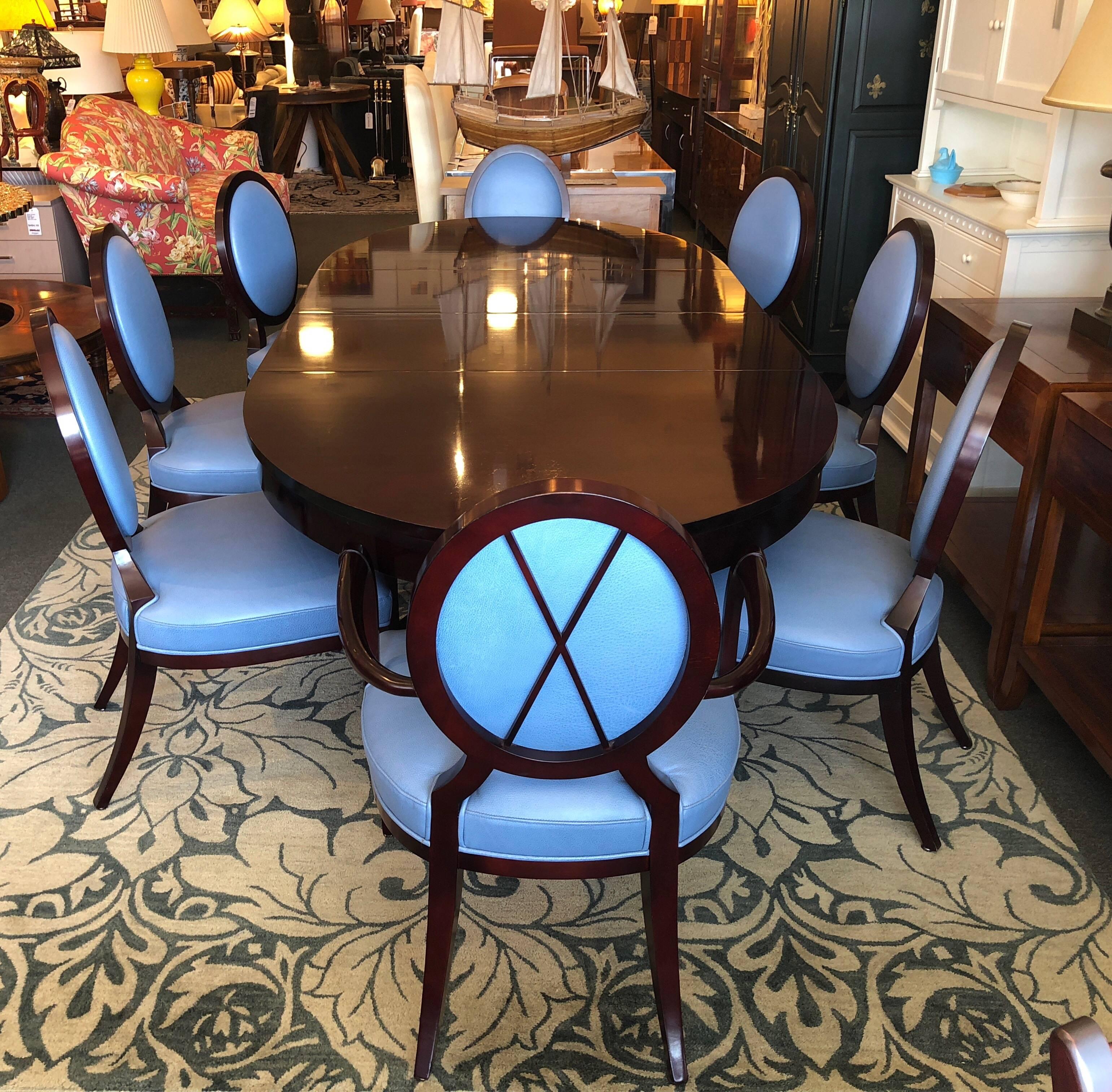 A fabulous dining set designed by Barbara Barry for Baker Furniture. The oval table as well as the chair frames are mahogany with a gloss finish. There are two arm chairs and six sides, they are upholstered in beautiful top grain Cornflower blue