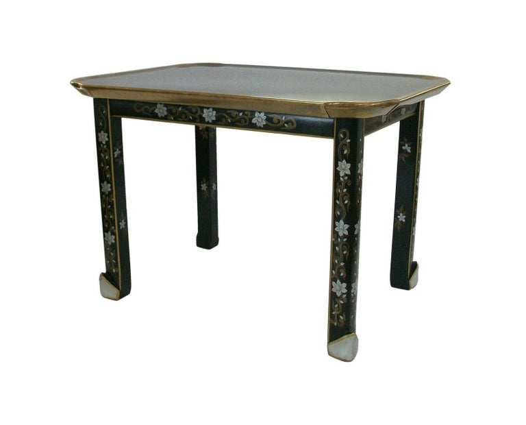 Baker Furniture - Rare vintage Chinoiserie cocktail / coffee table - exceptional quality with aged patina - featuring a brass top with hand hammered pie crust edge - hand painted floral and vine design to the satin black apron and legs - horse hoof