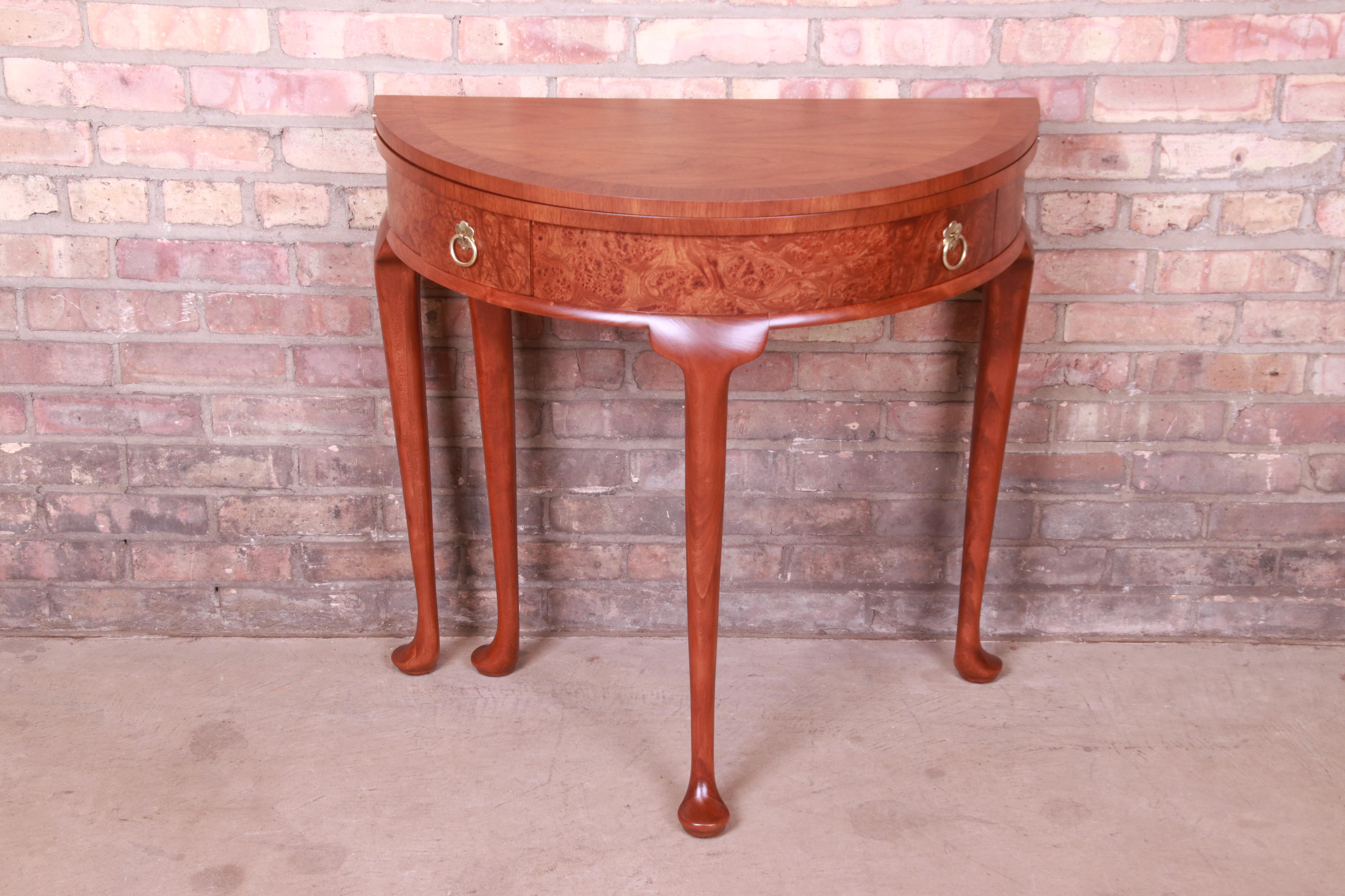 An exceptional petite Queen Anne style flip top demilune console table or entry table

By Baker Furniture

USA, Circa 1980s

Walnut, with burled walnut drawer fronts and original brass hardware.

Measures: 30
