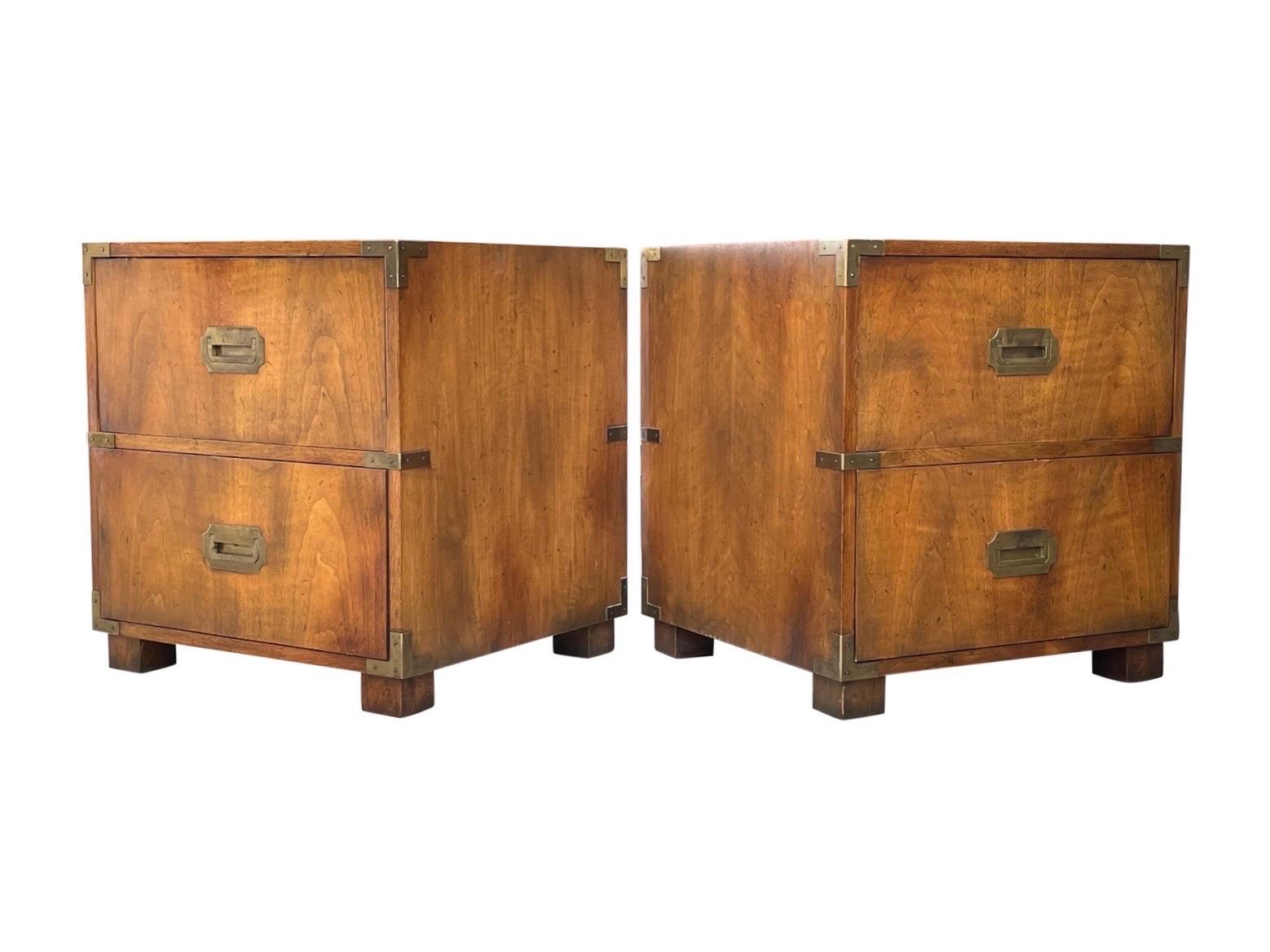 Pair of Baker Furniture midcentury Campaign style nightstands made of mahogany with brass hardware and unique fold down drawer front. With original Baker label.