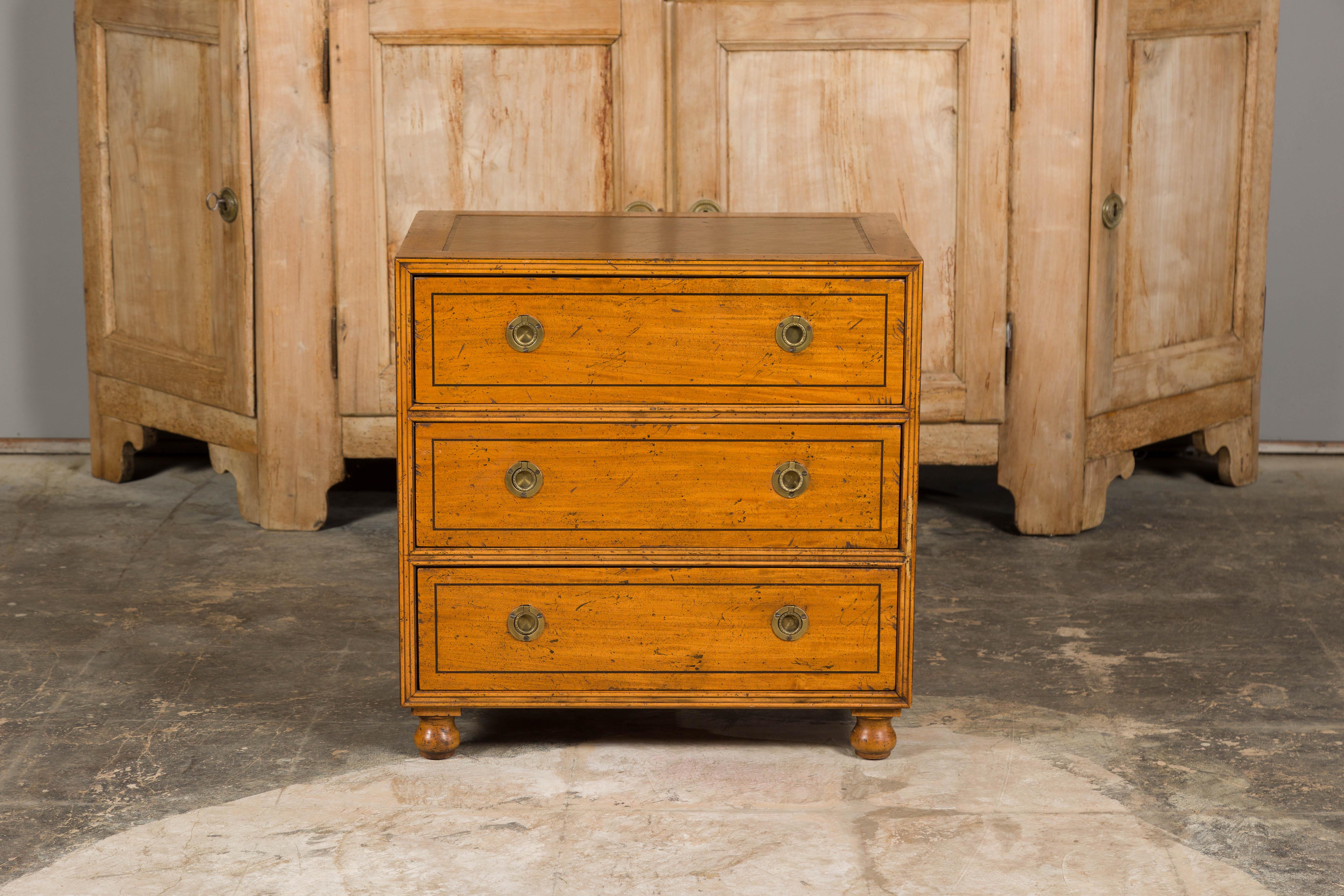A Baker Furniture Company Campaign style mahogany chest from circa 1950 with three drawers and brass hardware. Crafted in the mid-20th century, this Campaign style mahogany chest by the renowned Baker Furniture Company, is a splendid representation