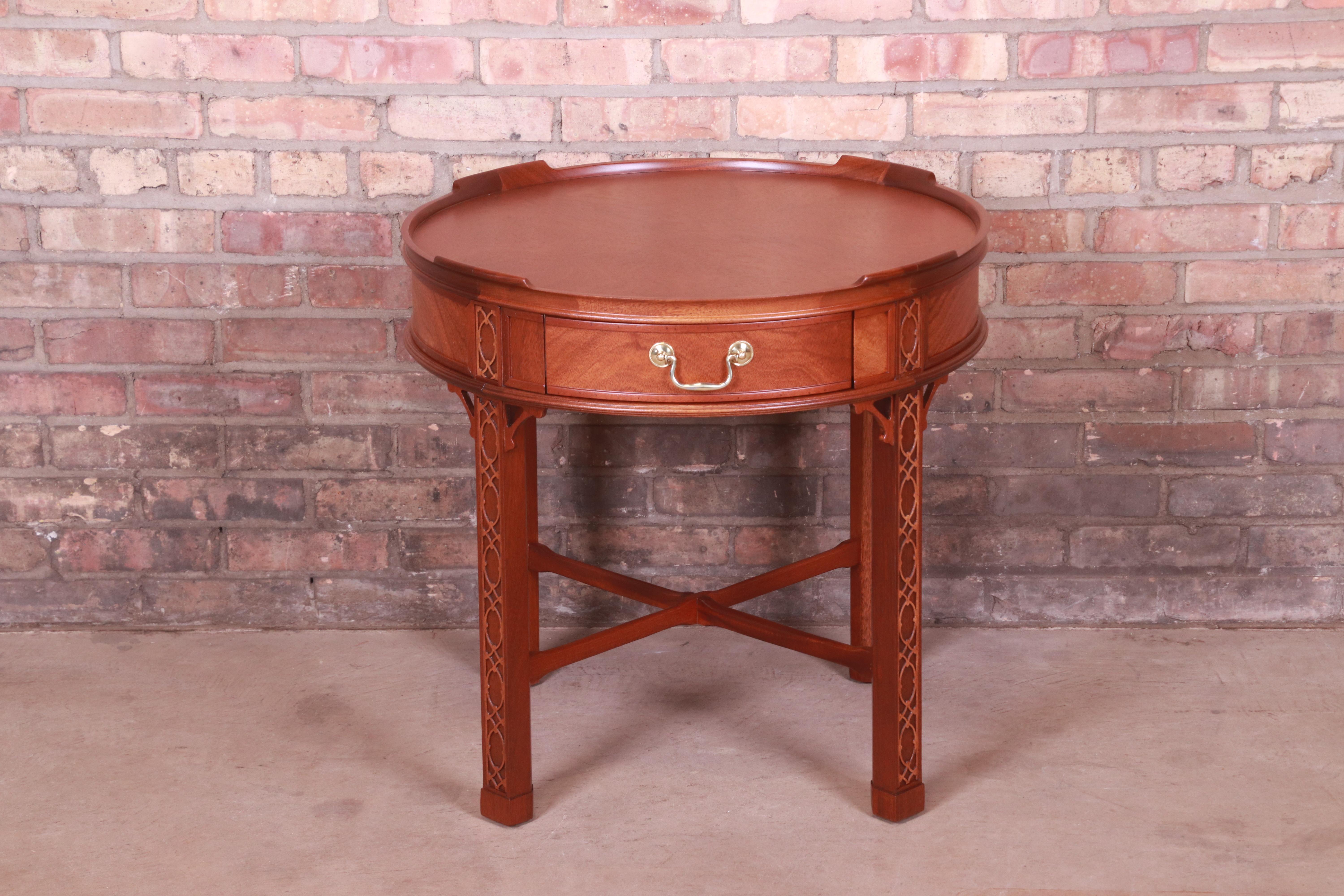 A gorgeous Chinese Chippendale style tea table or occasional side table

By Baker Furniture

USA, Circa 1980s

Carved mahogany, with original brass hardware.

Measures: 25.5