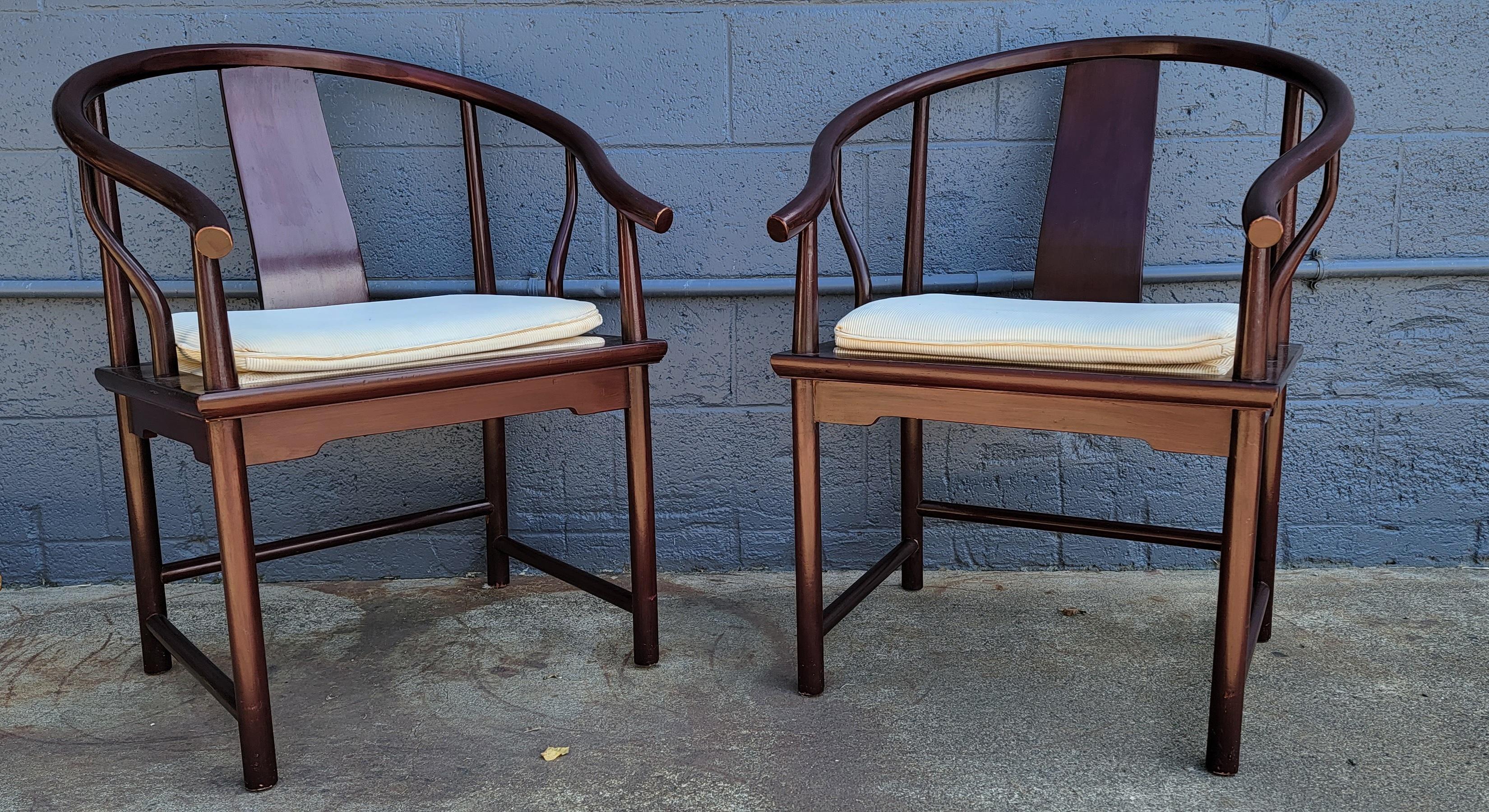 A pair of Chinese style horseshoe back armchairs by Baker Furniture Company. Retaining metal 