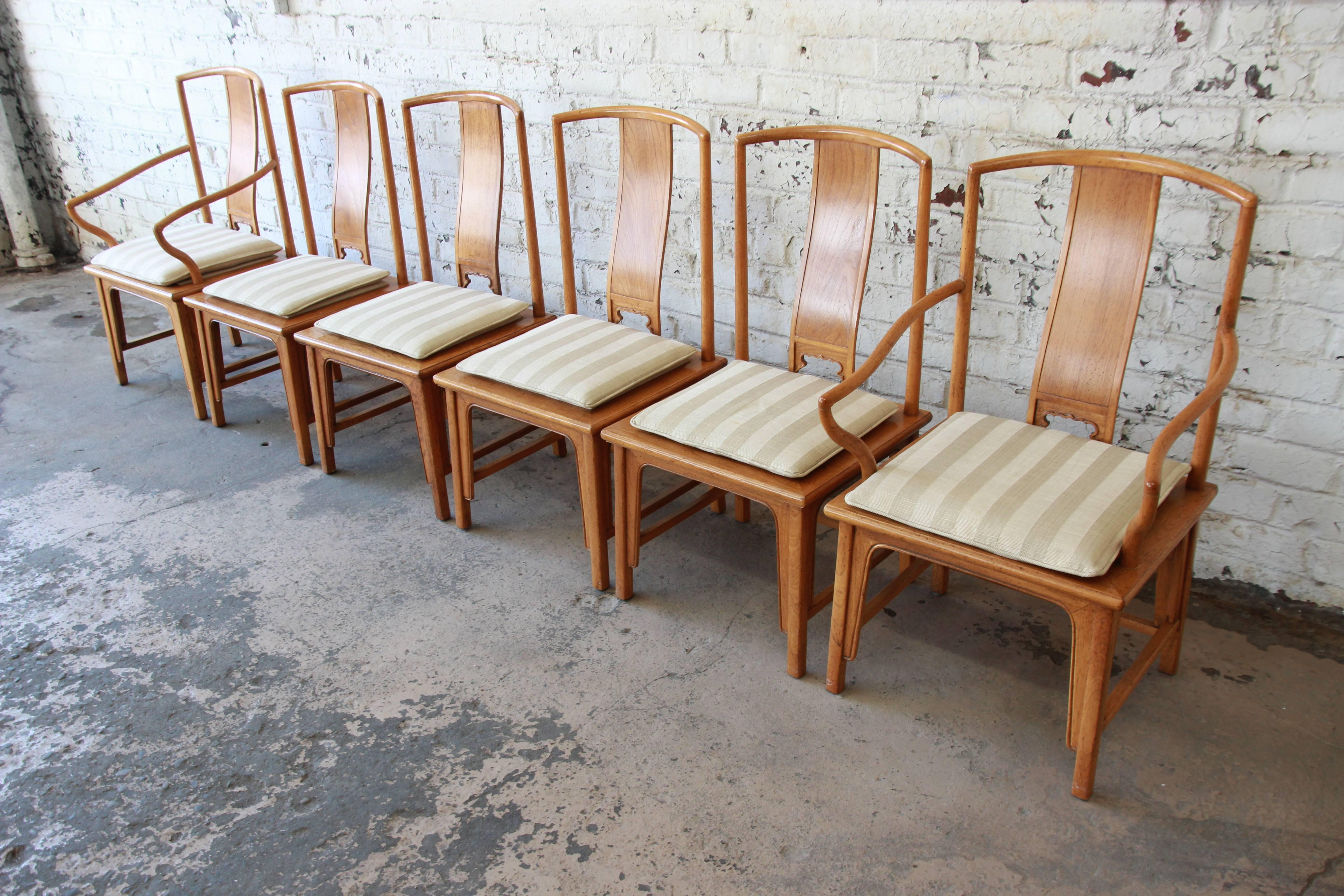 Offering an outstanding set of six Chinoiserie Ming style dining chairs by Baker Furniture. The set includes two captain chairs and four side chairs. The chairs feature solid elm wood construction, high curved backs, and a nice Asian flair. The