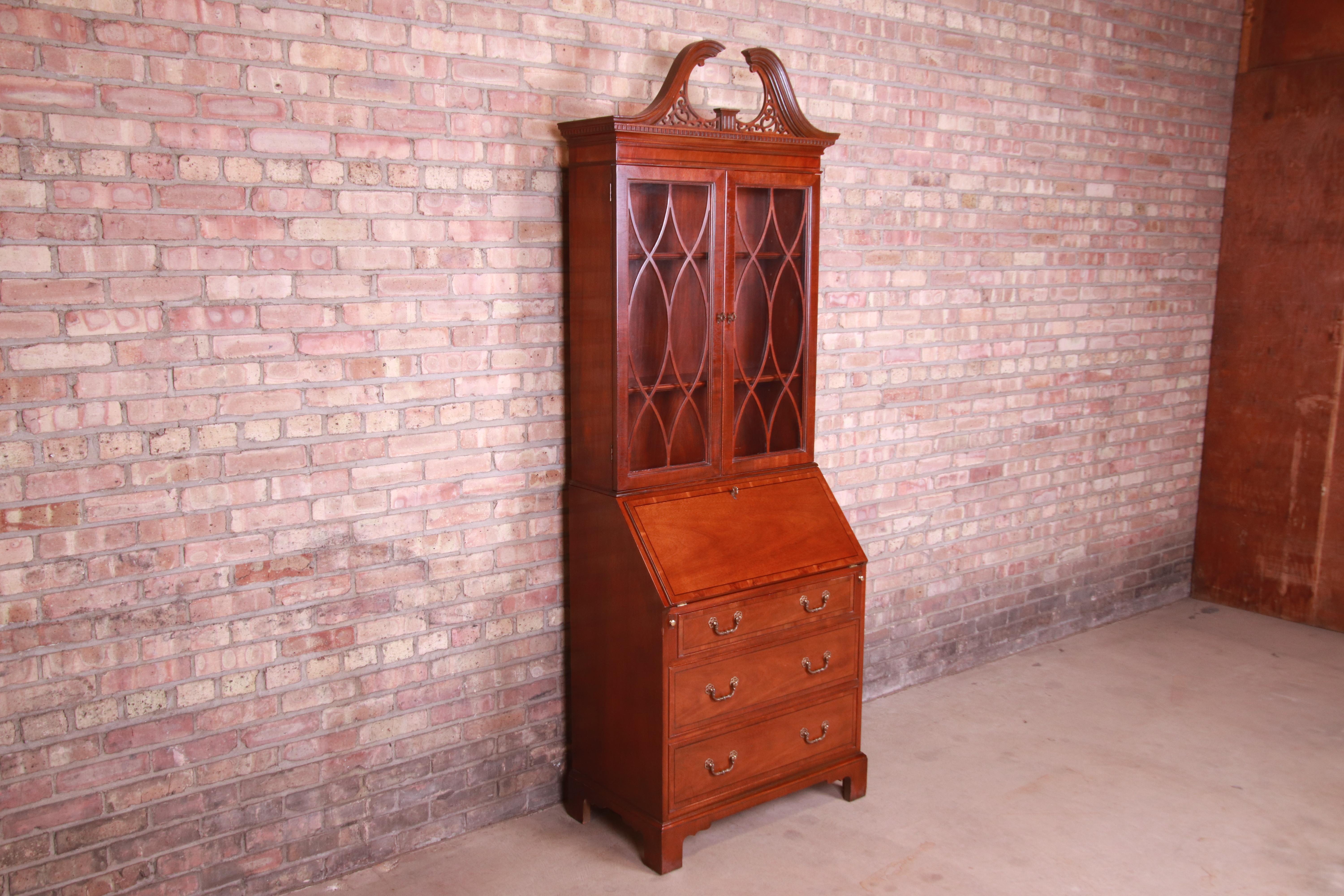 An exceptional Chippendale style secretary desk with bookcase hutch

By Baker Furniture

USA, Late 20th Century

Banded mahogany, with mullioned glass front doors and original brass hardware.

Measures: 32