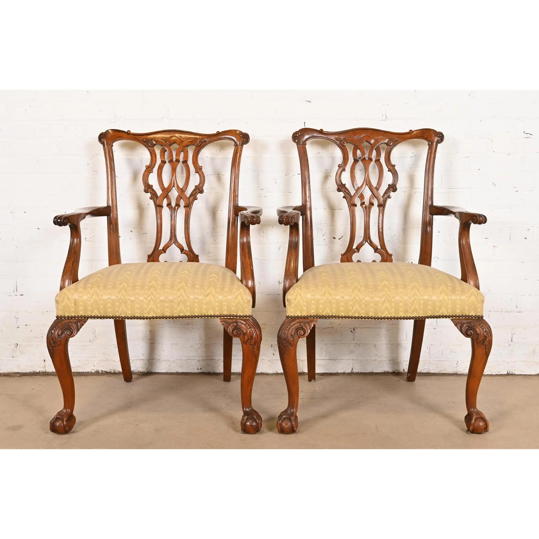 Une paire exceptionnelle de fauteuils ou de chaises capitaines de salle à manger de style Chippendale ou géorgien.

Par Baker Furniture

USA, Circa 1980

Montures en acajou massif, sièges rembourrés et cloutés de laiton, pieds sculptés en forme de