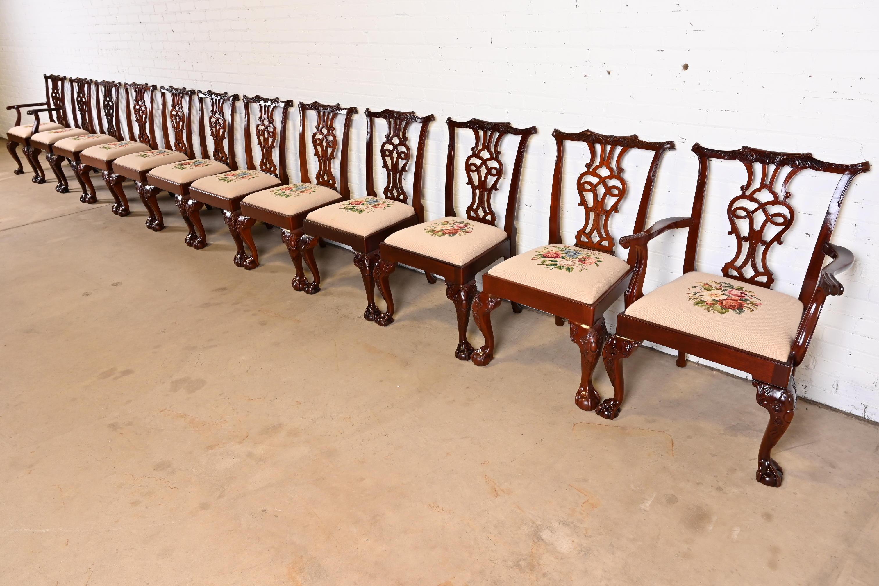 An outstanding set of twelve English Chippendale or Georgian style dining chairs

By Baker Furniture

USA, late 20th century

Carved mahogany, with custom floral needlepoint upholstered seats.

Measures:
Side chairs - 24.5