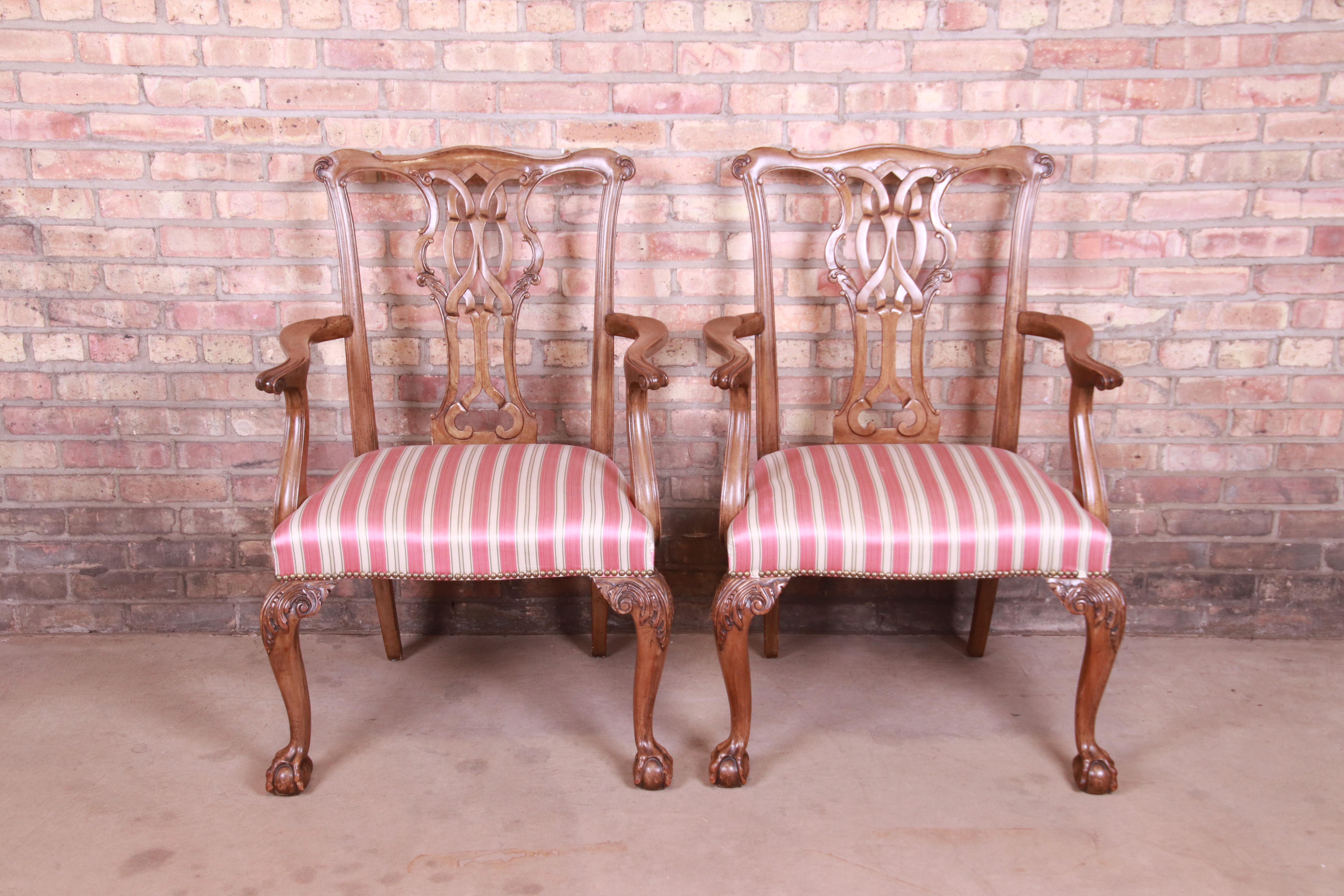 A gorgeous pair of club chairs or dining armchairs

By Baker Furniture

USA, Circa 1980s

Solid carved walnut frames with ball and claw feet, and ivory and pink upholstered seats.

Measures: 26.75