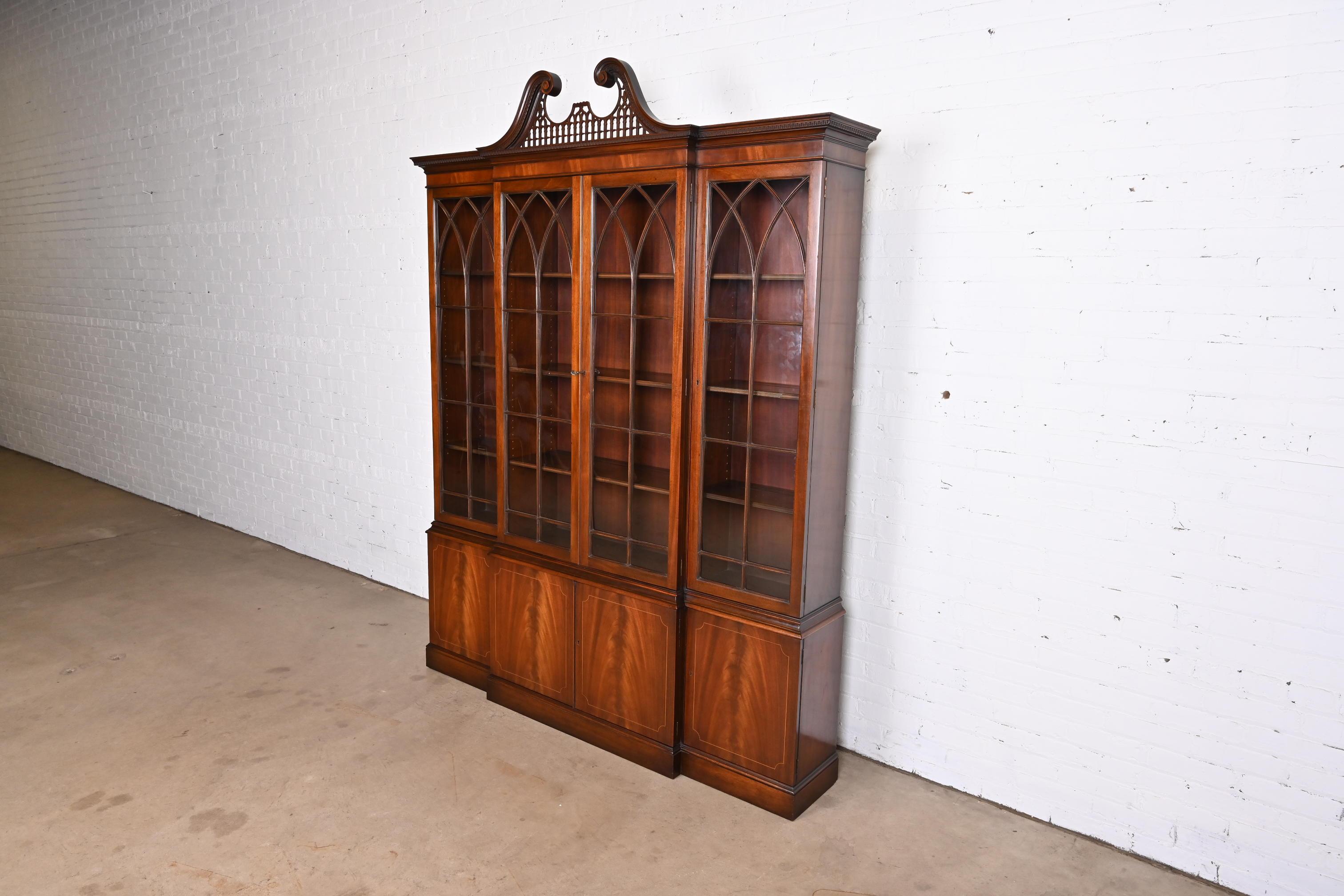 A gorgeous Georgian or Chippendale style breakfront bookcase cabinet or dining cabinet

By Baker Furniture

USA, Circa 1980s

Stunning book-matched flame mahogany, with satinwood string inlay, mullioned glass front doors, and original brass