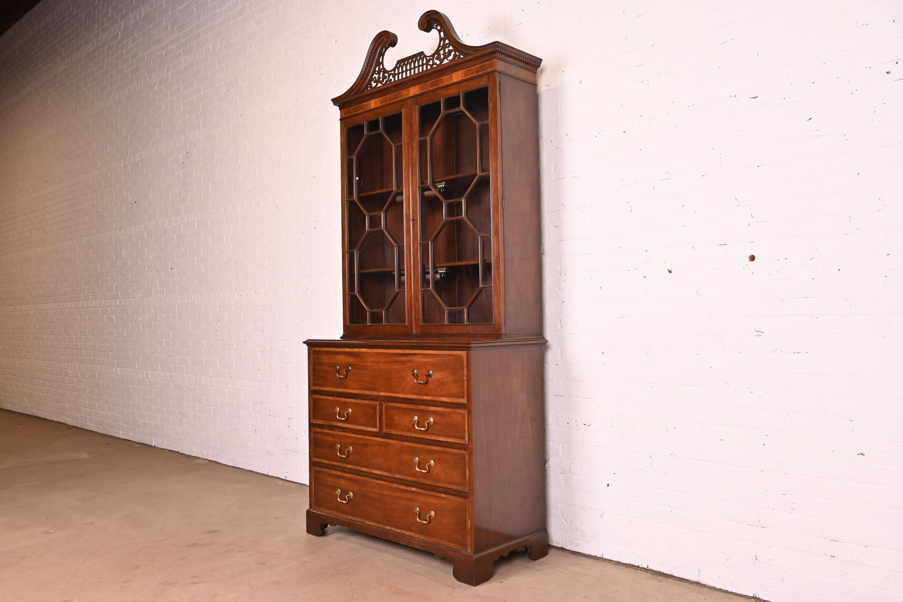 A gorgeous Chippendale or Georgian style bureau with drop front secretary desk and lighted bookcase hutch top

By Baker Furniture

USA, Circa 1980s

Carved mahogany, with satinwood banding, embossed leather writing surface, mullioned glass