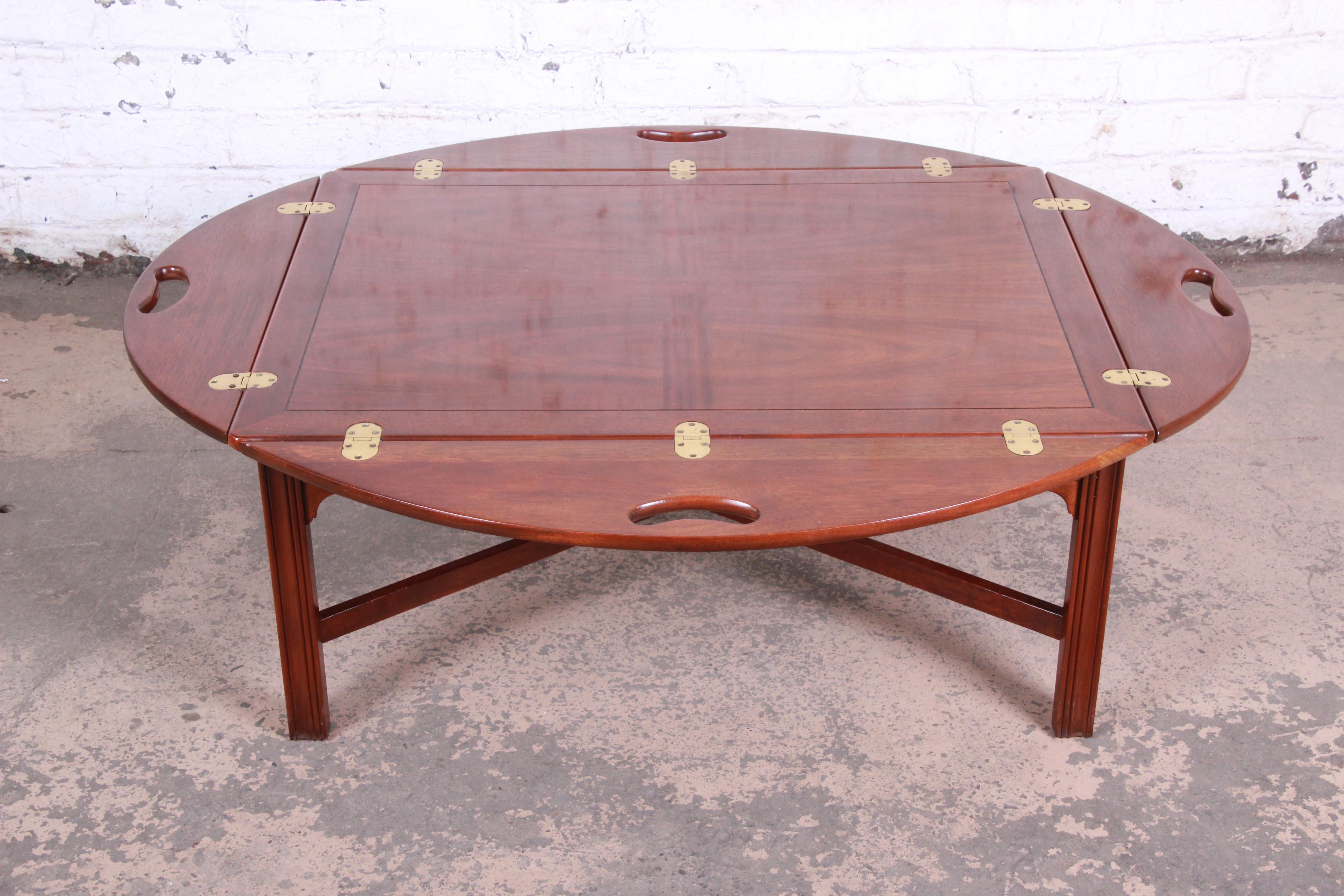 A gorgeous Chippendale style mahogany butler's coffee table by Baker Furniture. The table features stunning mahogany wood grain, with brass hinges and X-base stretchers. Made with the highest quality craftsmanship, as expected from Baker. The