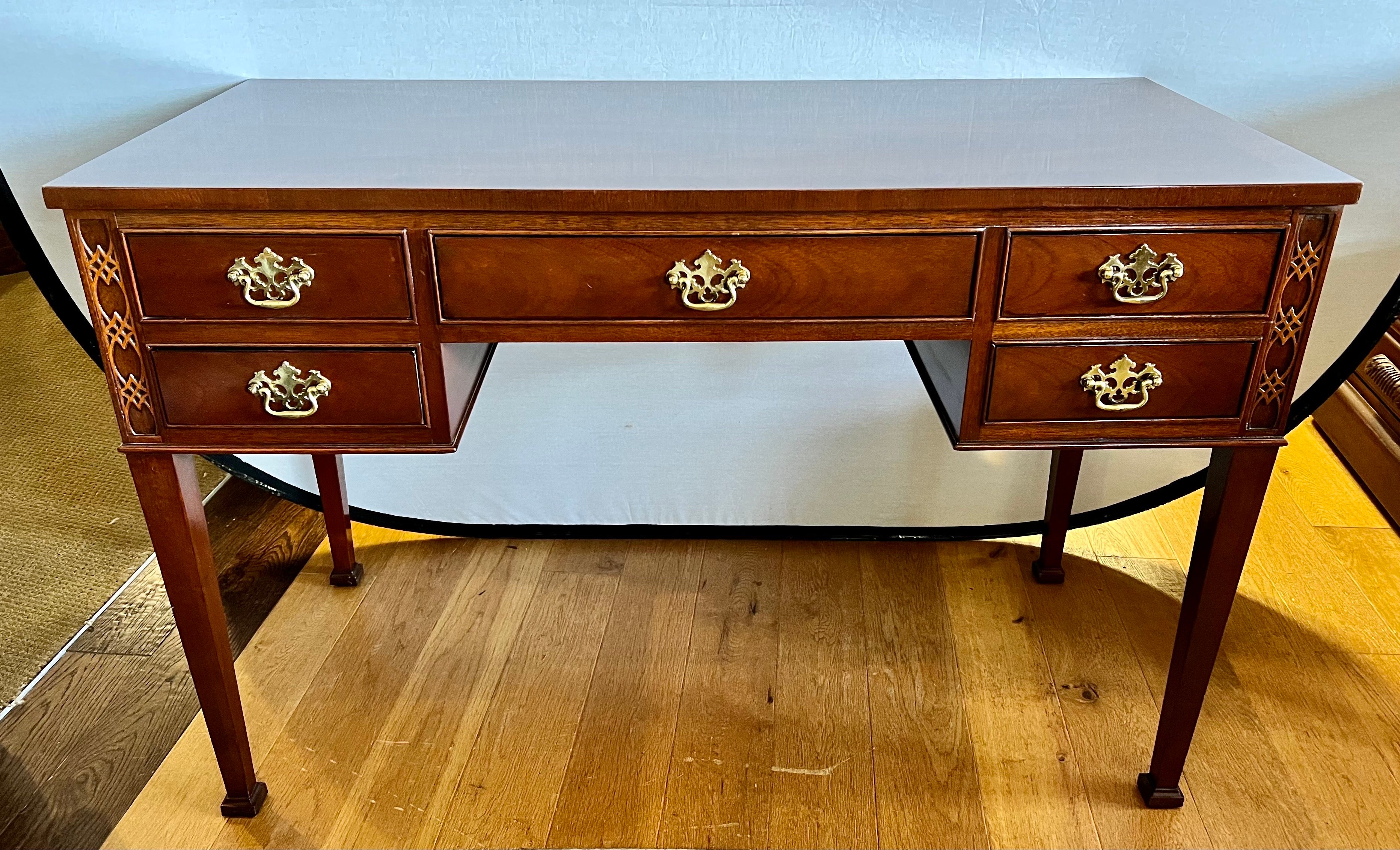 From one of the most well respected American furniture makers, this Baker Furniture writing desk is an heirloom quality piece.  In solid wood with finely designed brass hardware and carved detail.  Desk is finished on all sides so that it can float