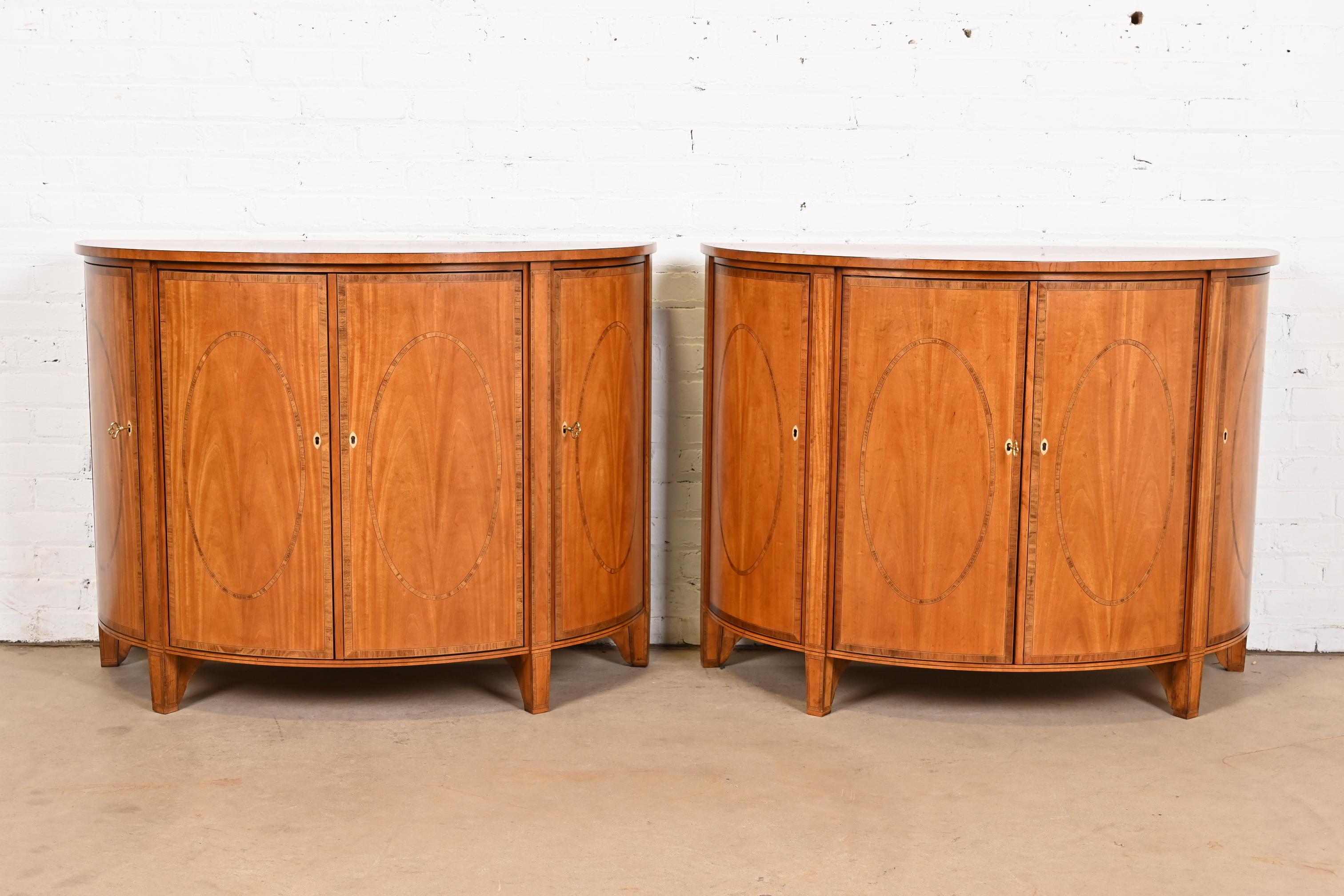 A gorgeous pair of Federal or Hepplewhite style demilune sideboards, cabinets, or console tables

By Baker Furniture, 