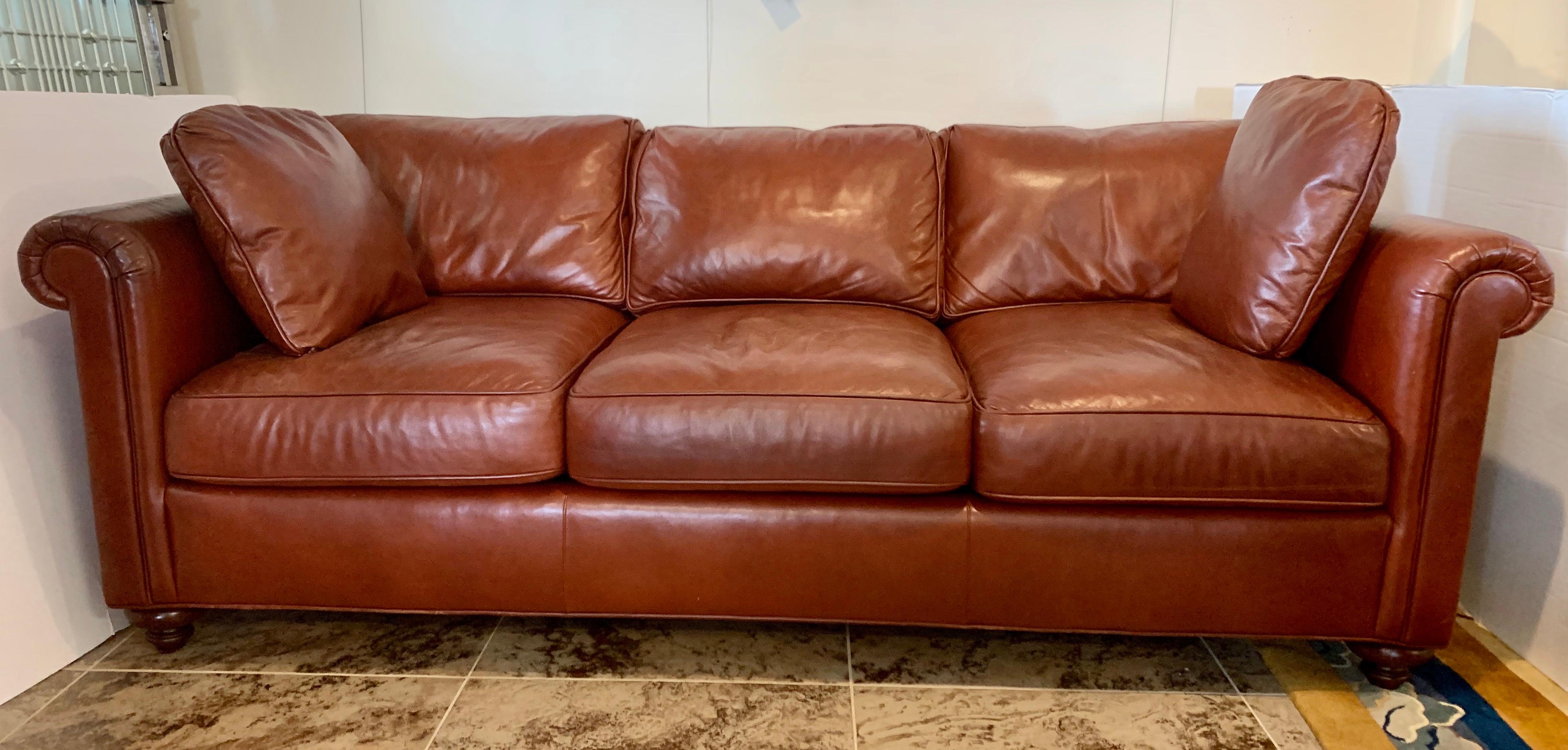 Elegant Baker Furniture large saddle brown leather sofa. Made in the USA. Features eight-way hand tied construction and down blended fill (see tags on pictures below for percentages). This Classic looking leather sofa, when made with the highest