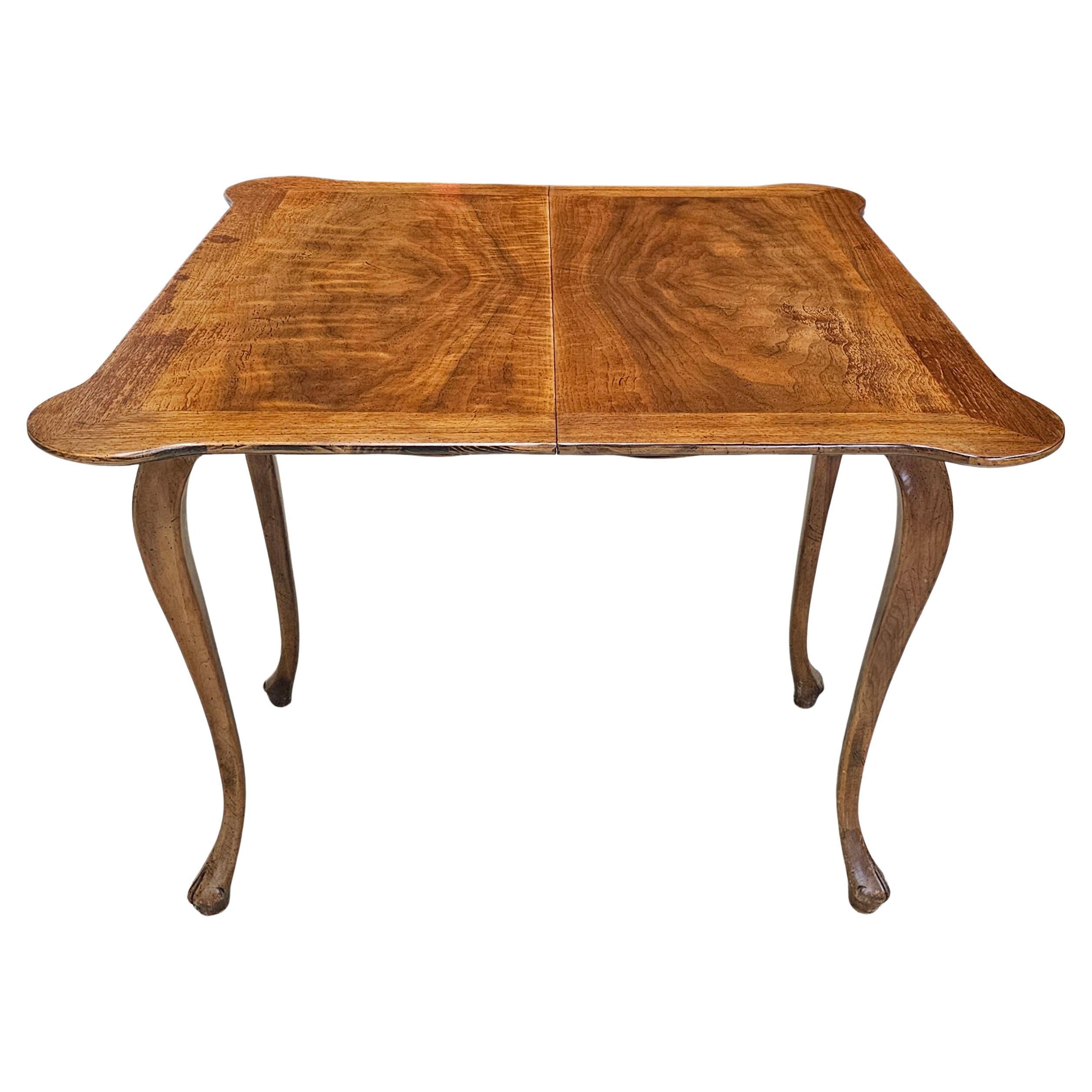 A mid-20th Century Baker Furniture  Cross-Banded Walnut and Walnut Burl Fold-Top Console / Game Table.
Measures 34