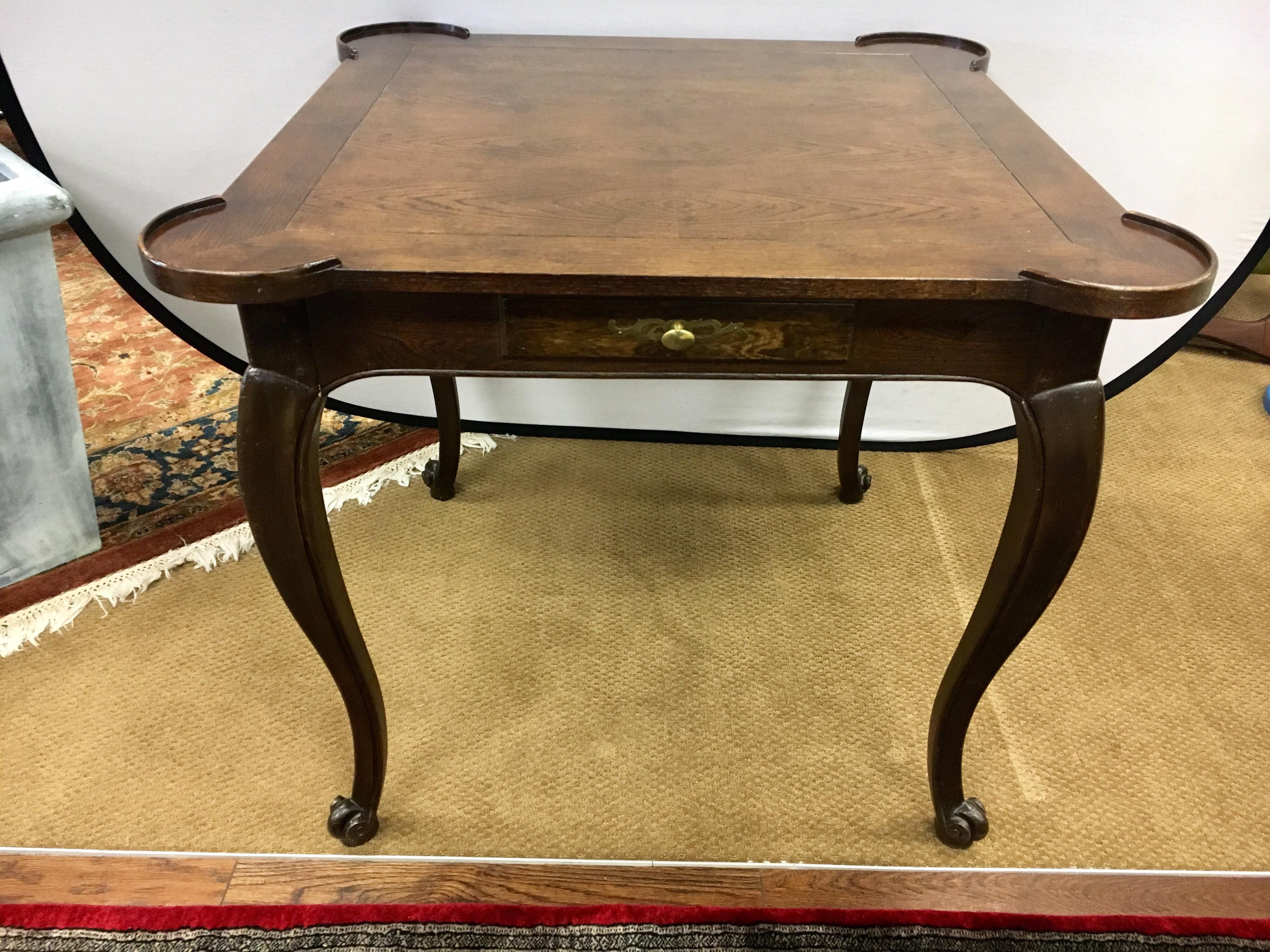 Signed Baker furniture dark walnut game table with one drawer for storing game pieces or cards. Each corner has a rounded area with a raised lip for cups.