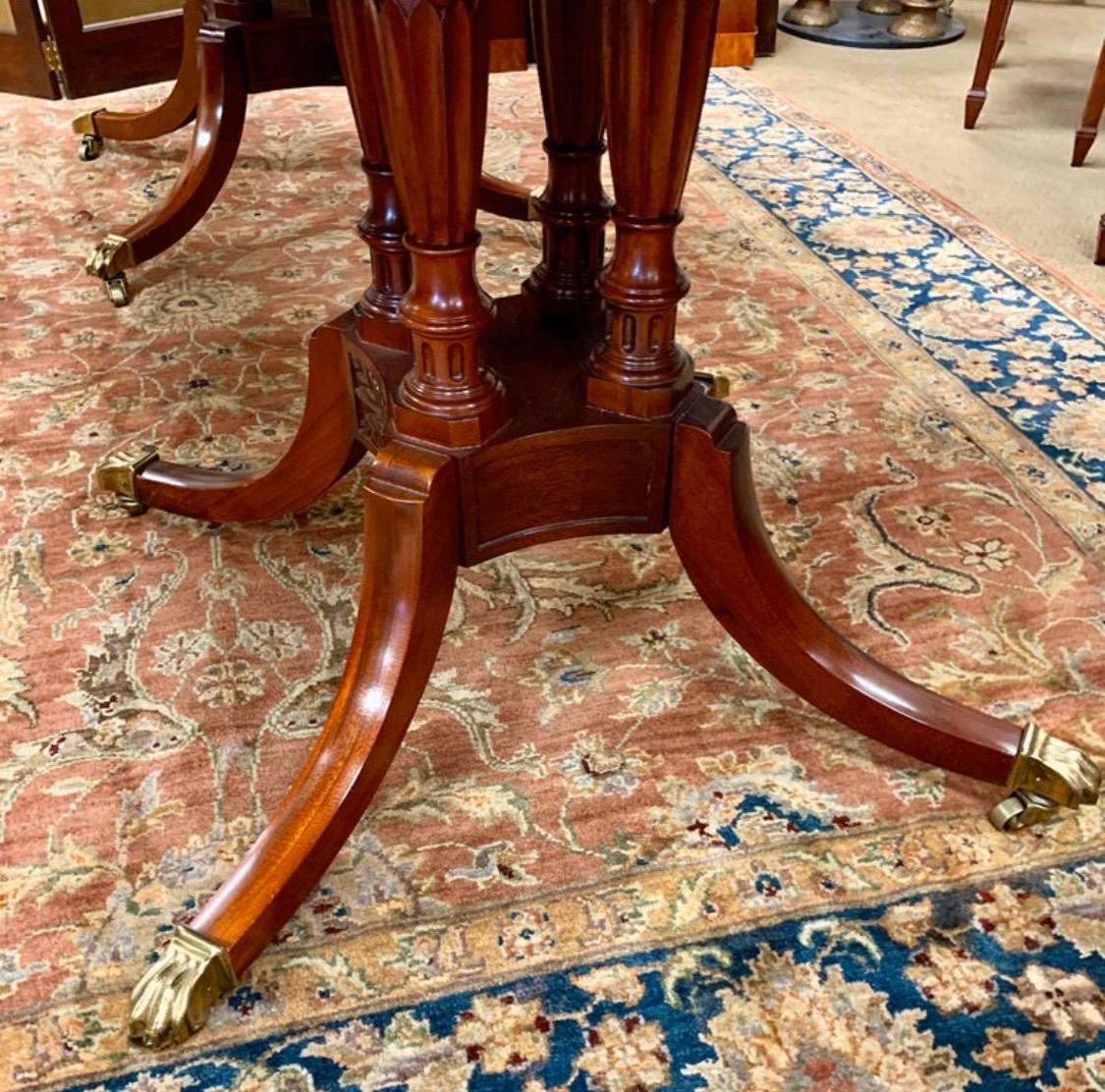 Stunning elegant Baker Furniture dining room set includes a double pedestal mahogany table with one leaf. Table features a banded inlay all around and brass paw feet. All Baker Furniture hallmarks are present.
The table expands from 70 inches to 88