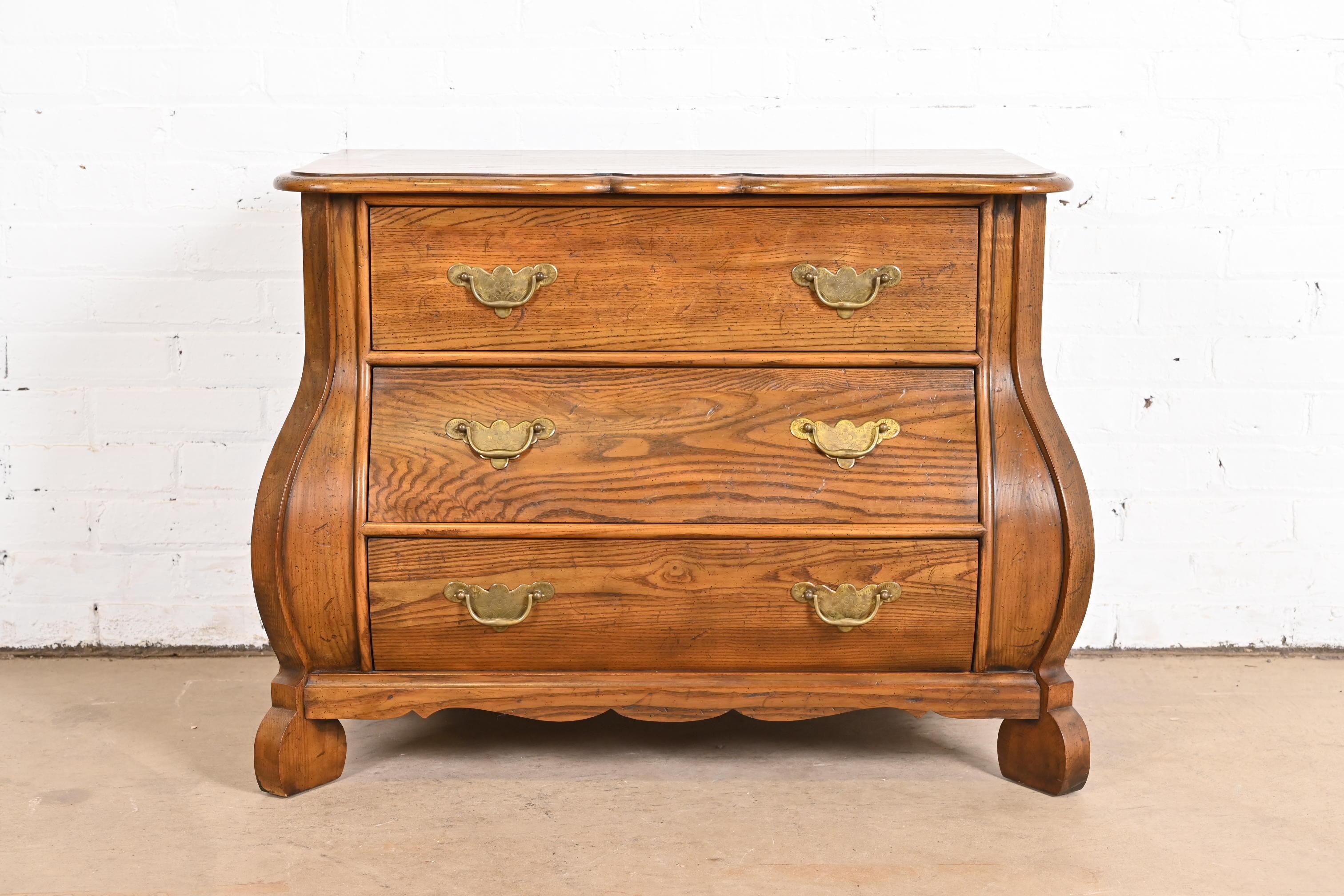 A gorgeous Dutch or French Provincial Louis XV style bombay chest, commode, or dresser

By Baker Furniture

USA, Circa 1960s

Solid oak, with original brass hardware.

Measures: 33.75