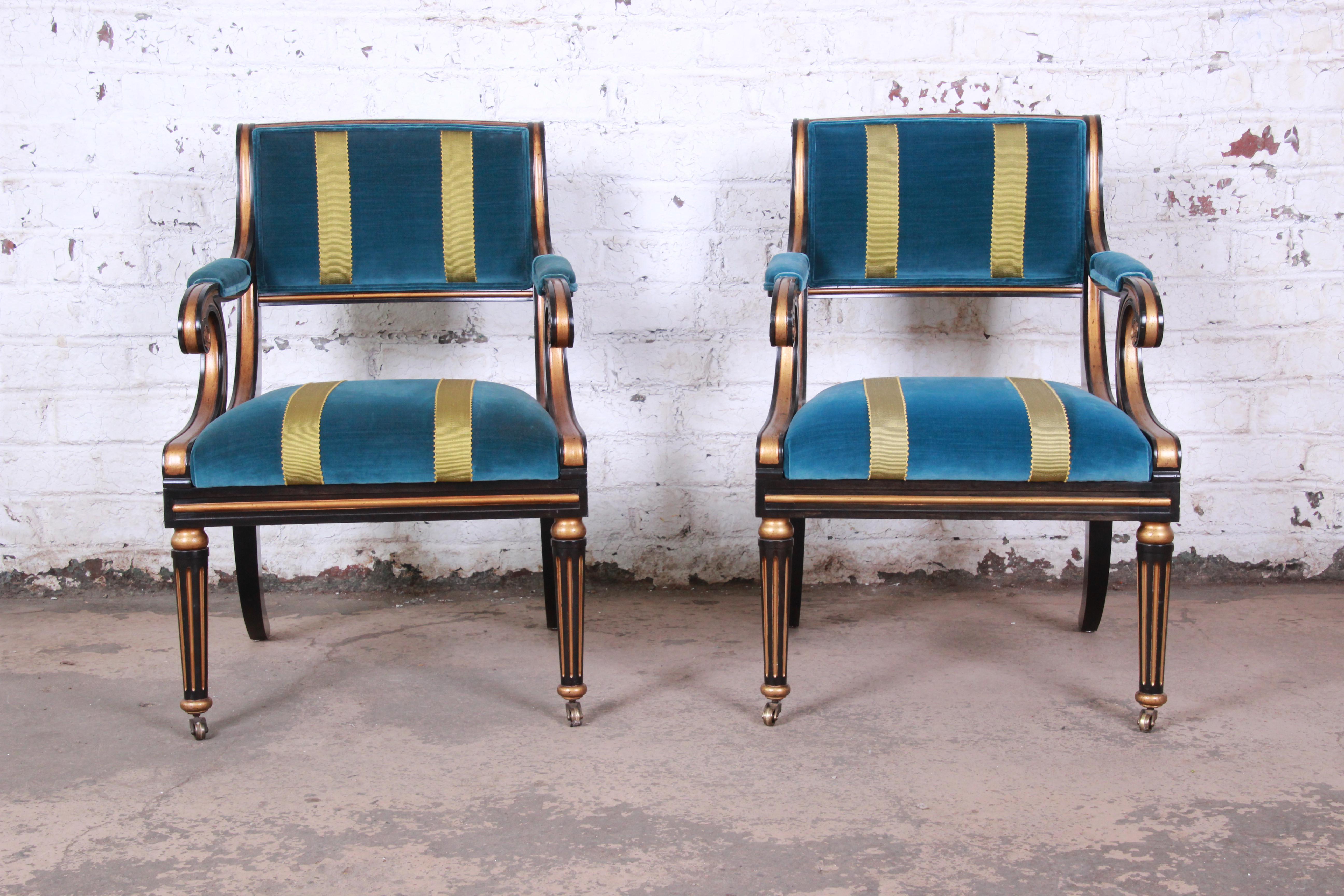 An exceptional pair of Regency style armchairs by Baker Furniture. The chairs feature stunning ebonized and gold gilt solid wood frames and teal mohair velvet upholstery with gold stripes. Made with the highest quality craftsmanship, as expected