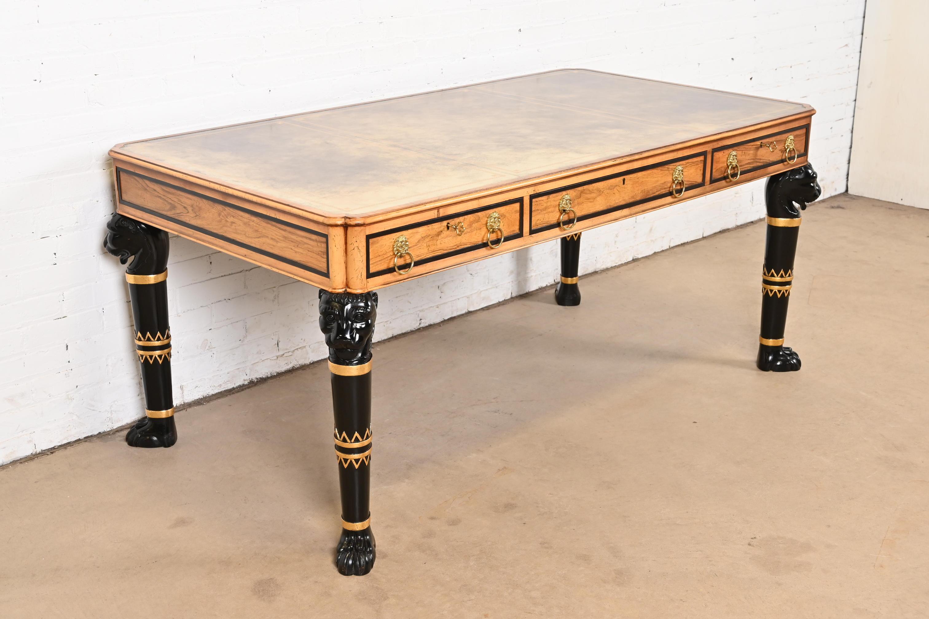 Magnifique bureau de direction ou bureau plat de style néo-égyptien, néoclassique ou empire.

Par Baker Furniture

États-Unis, fin du 20e siècle

Bois de rose, plateau en cuir gaufré, pieds ébonisés et dorés avec têtes de lion et pieds en patte