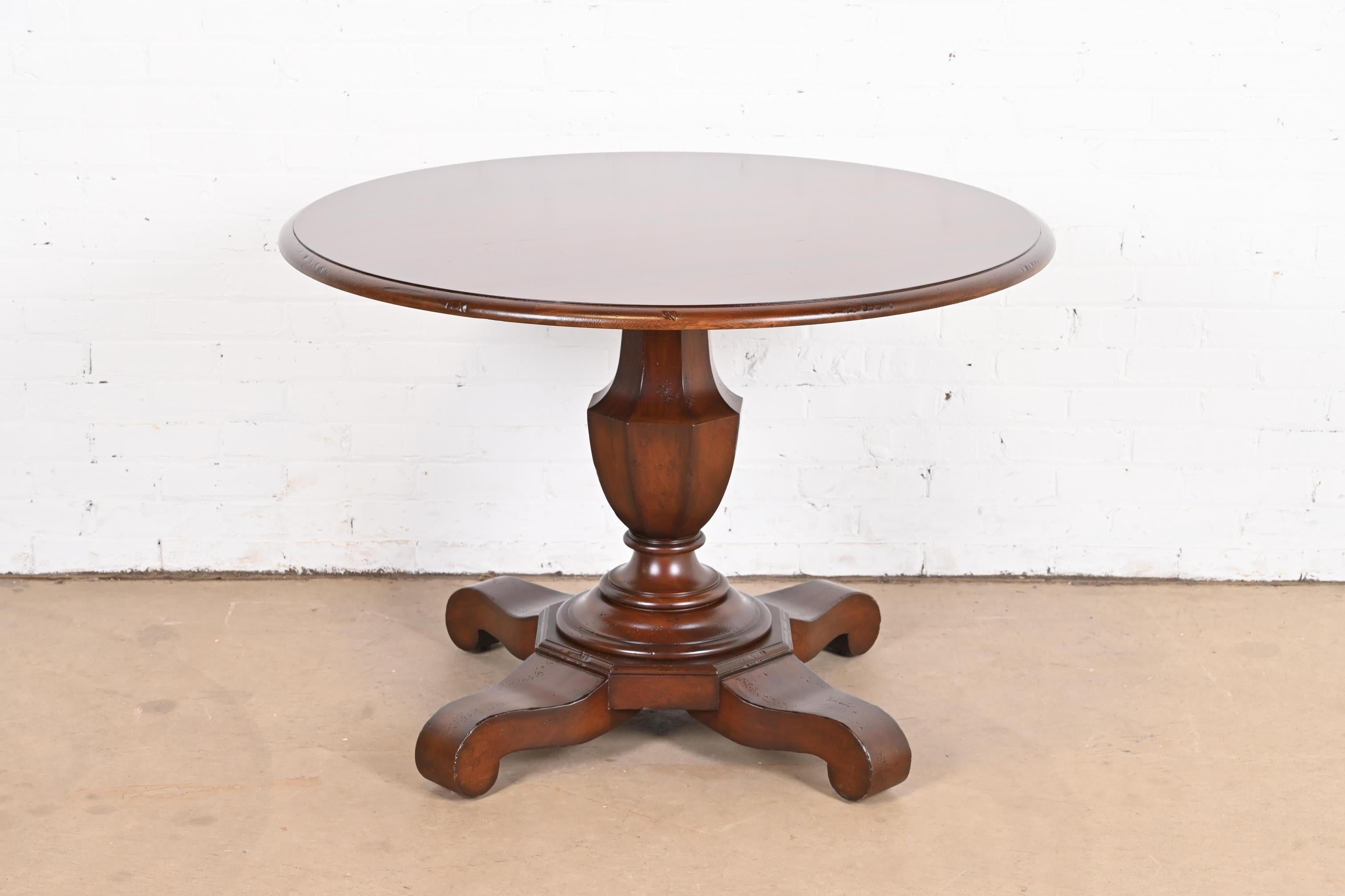 A gorgeous Empire style carved mahogany pedestal tea table, dining table, or center table

By Baker Furniture, 