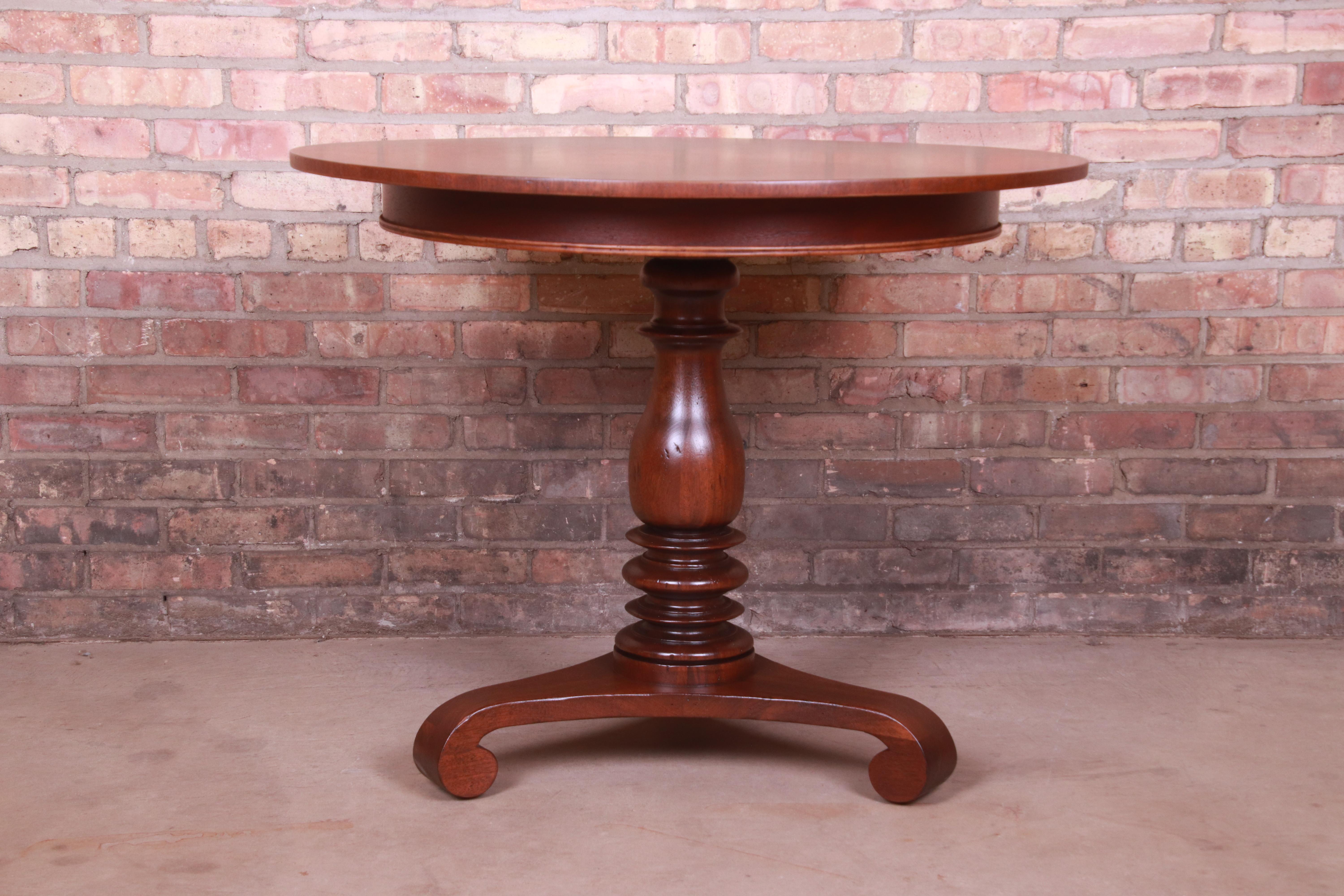 A gorgeous Empire style carved mahogany pedestal tea table or center table

By Baker Furniture, 