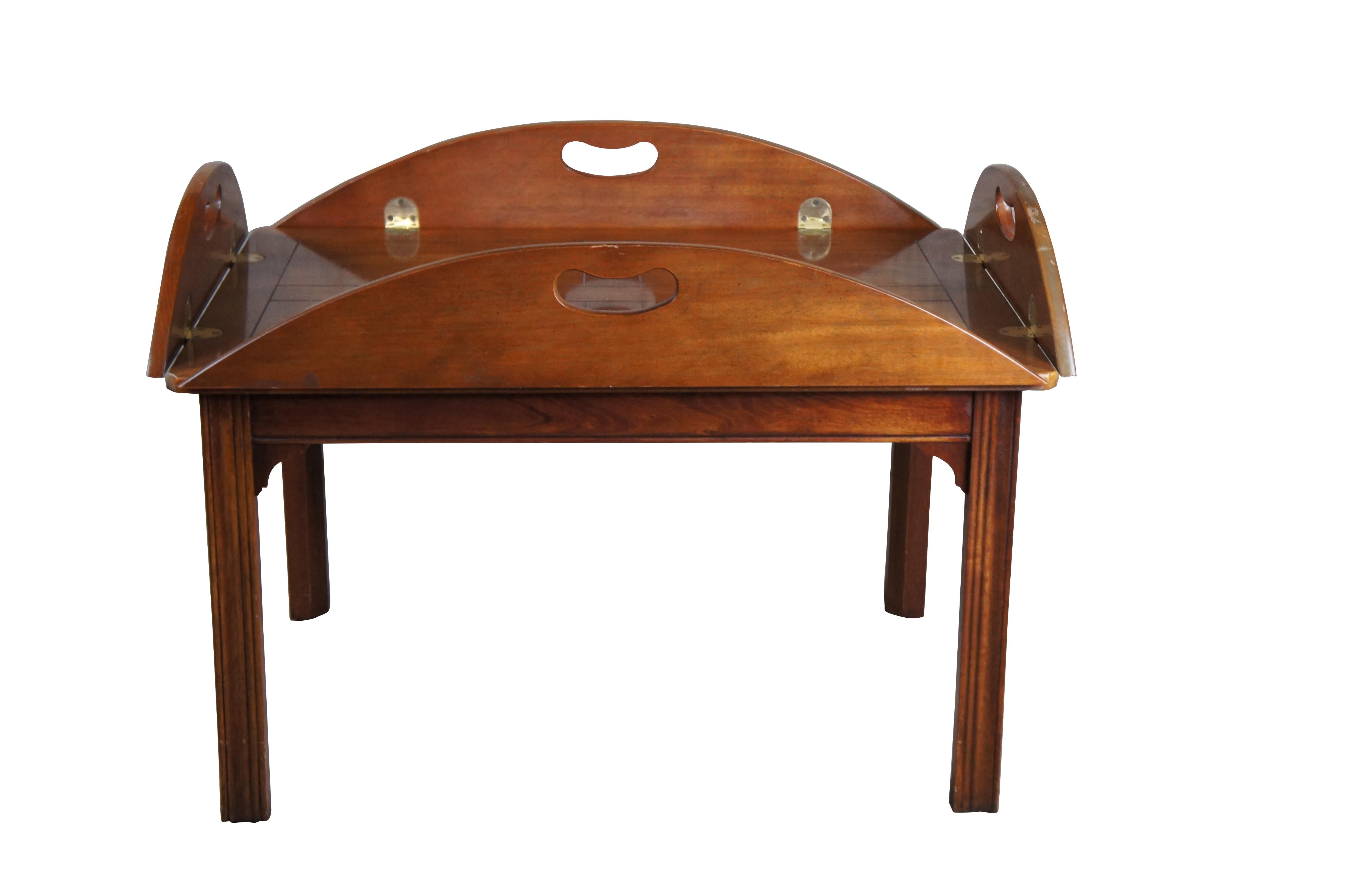 Tavolino da caffè con vassoio Baker Furniture English Chippendale Campaigner Stye Butlers, CIRCA anni '80.  Presenta una forma ovale in mogano con cerniere in ottone che permettono di sollevare la parte superiore e di trasportarla come vassoio