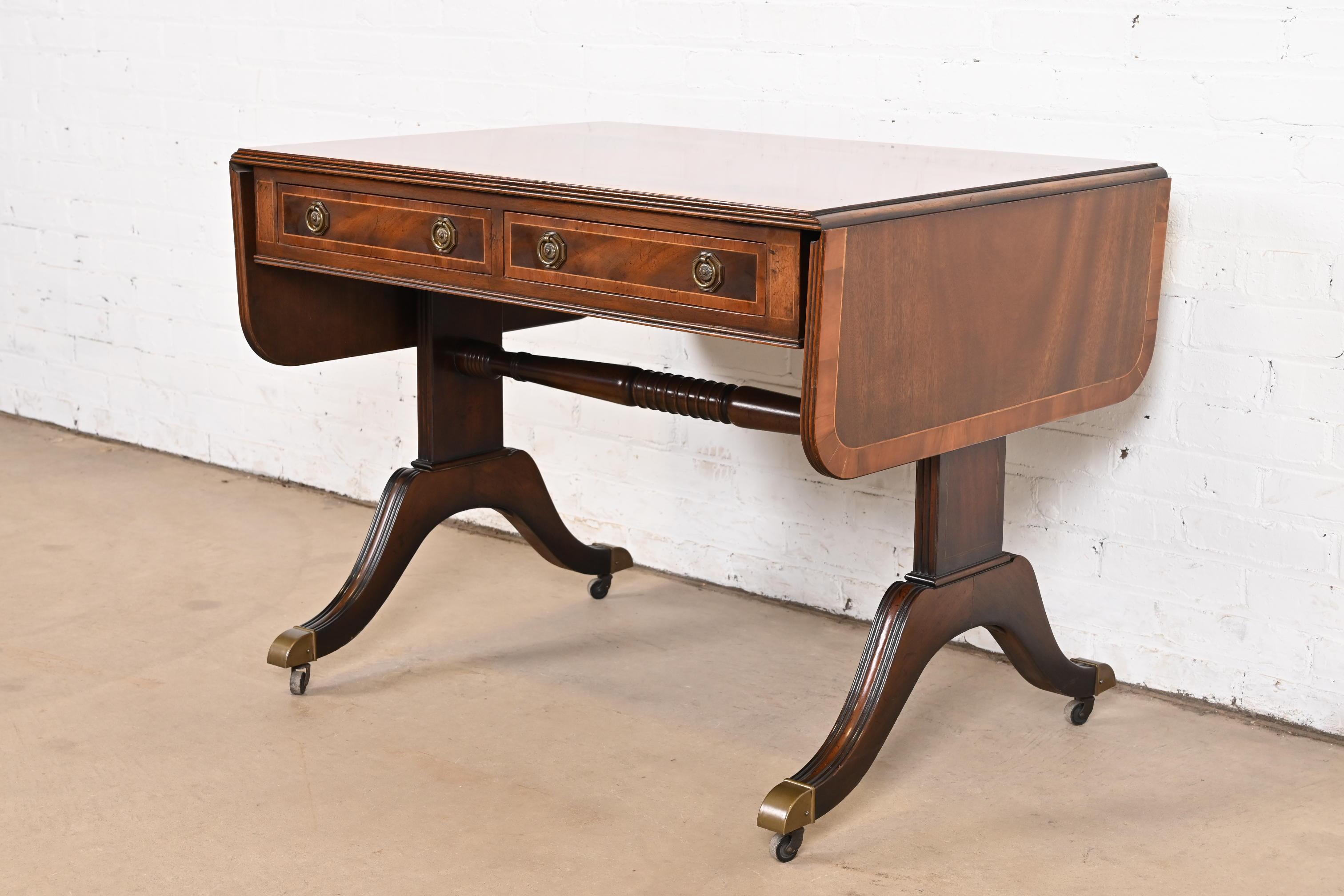 Ein außergewöhnlicher englischer Schreibtisch, Konsolentisch oder Sofatisch im Regency- oder georgianischen Stil

Von Baker Furniture

USA, ca. 1940er Jahre

Mahagoni, mit englischer Eibenholzumrandung, Satinholz-Saiteneinlage und originalen